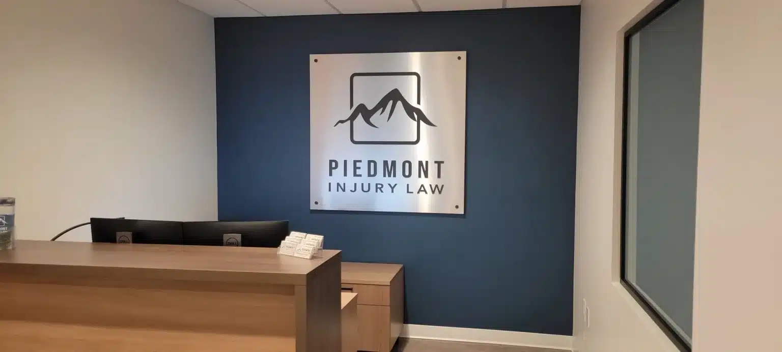 Reception logo sign on accent wall, Piedmont Injury Law, Kennesaw, GA, by High Stakes Creative