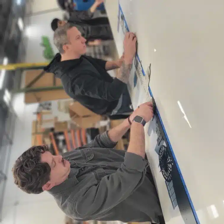 Professional team installing a custom sign on a storefront, showcasing teamwork and precision