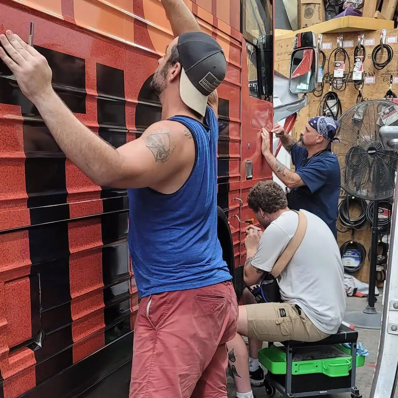 Professional technician applying a vehicle wrap in a workshop, demonstrating expert installation techniques
