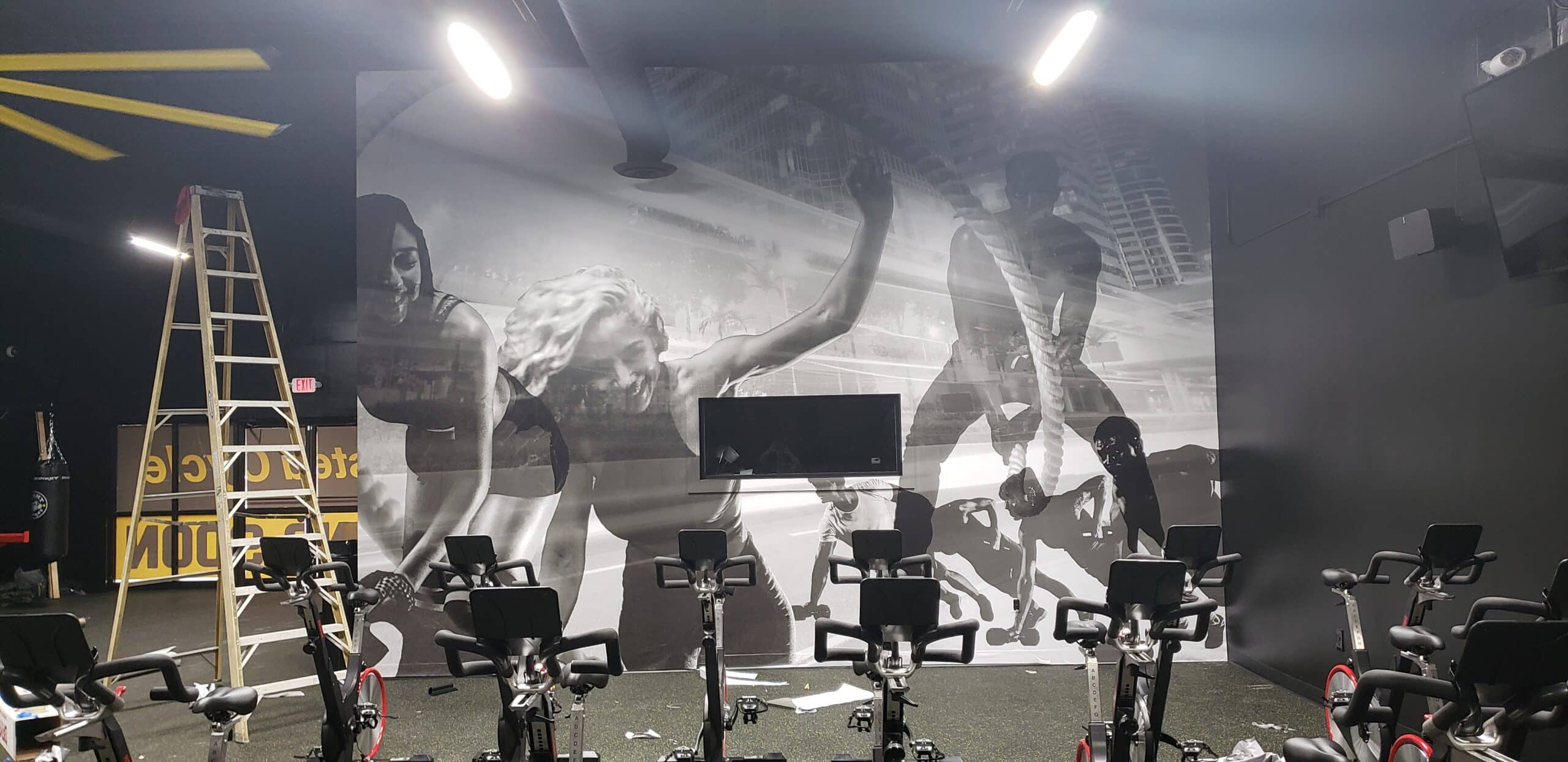 Black-and-white athlete murals in the spin room, Twisted Cycle, Woodstock, GA, by High Stakes Creative