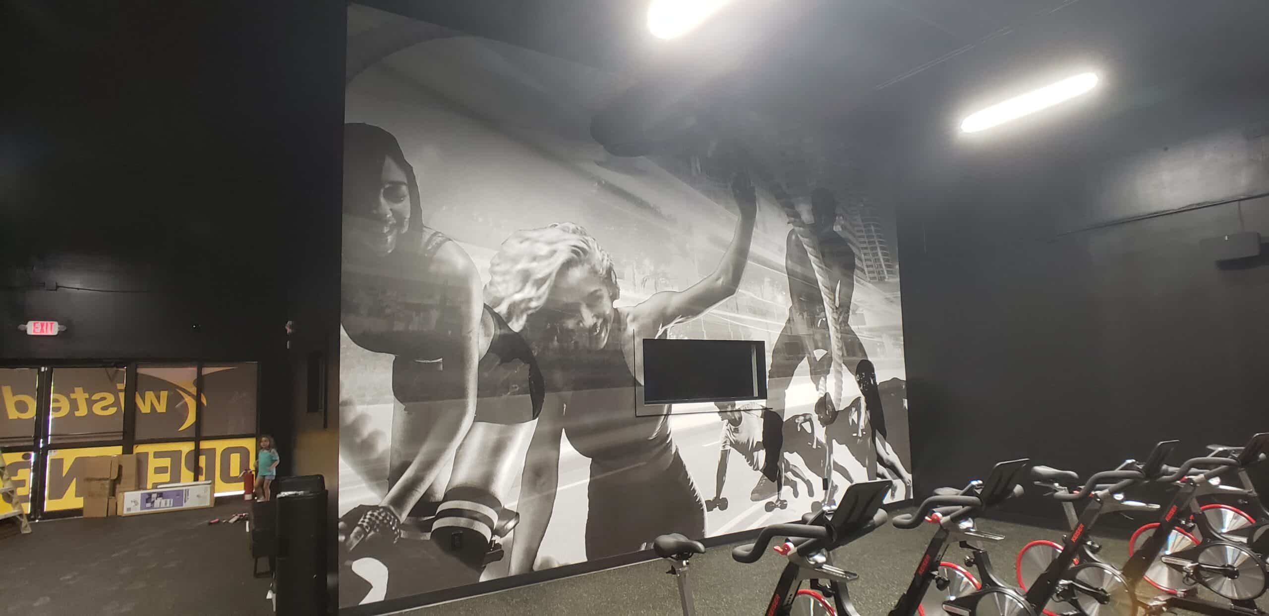 Black-and-white athlete murals in the spin room, Twisted Cycle, Woodstock, GA, by High Stakes Creative