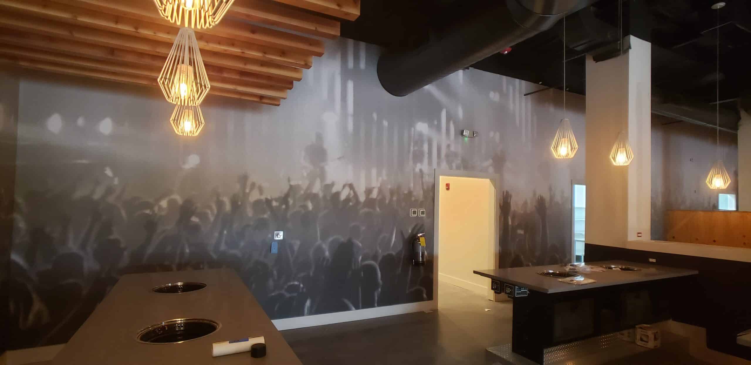 Concert crowd wallcovering for a restaurant and bar, by High Stakes Creative