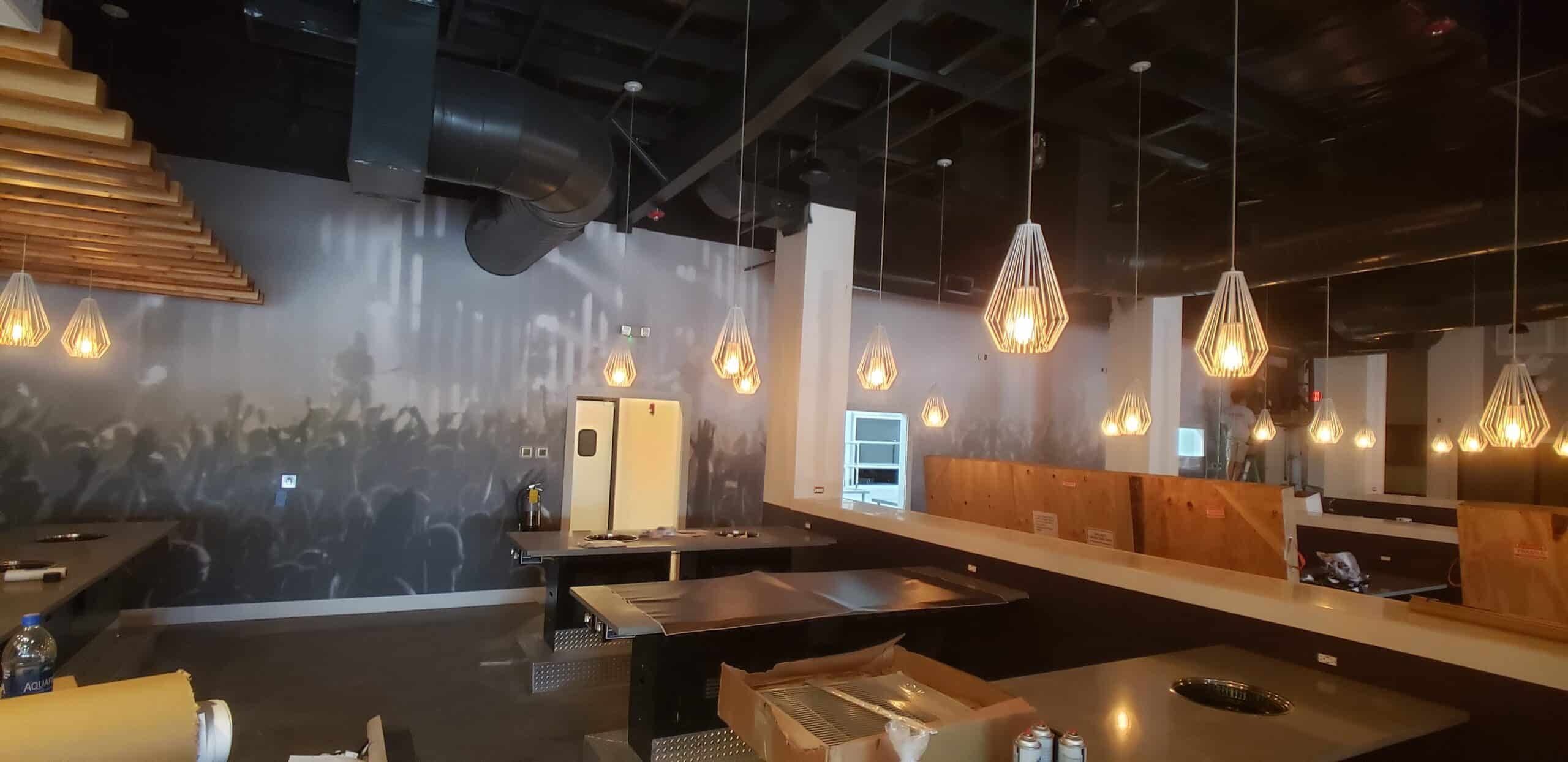 Concert crowd wallcovering for a restaurant and bar, by High Stakes Creative