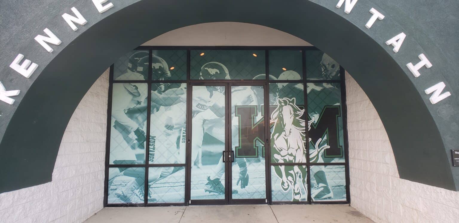 Perforated/printed window graphics with football photos and KM mustang logo at arched scho, Kennesaw Mountain, Kennesaw, GA, by High Stakes Creative