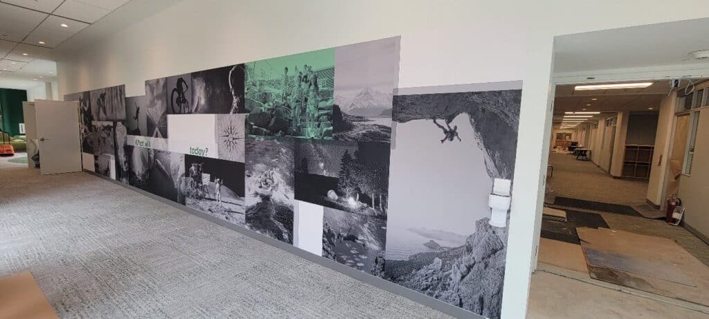 Long black-and-white photo collage corridor mural (landmarks, adventure scenes) with "What, by High Stakes Creative