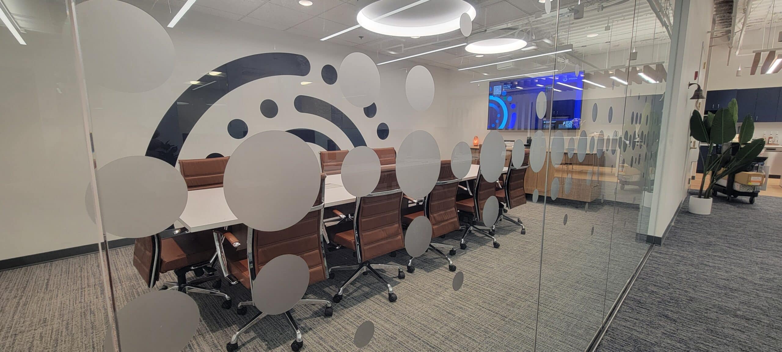 Brand mark wall behind conference room glass, Informa, Sandy Springs, GA, by High Stakes Creative
