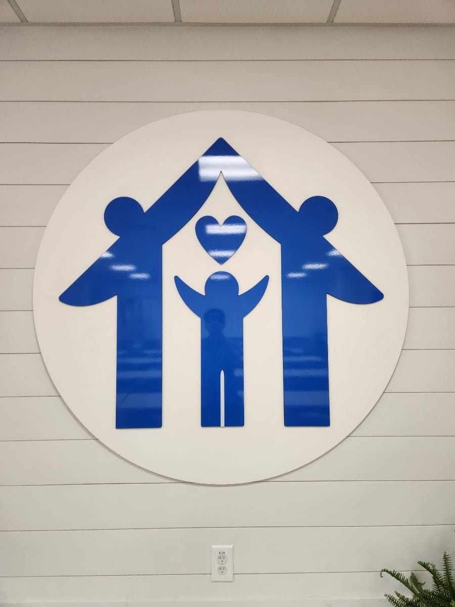 Large circular logo on shiplap wall, Advocates for Children, Cartersville, GA, by High Stakes Creative