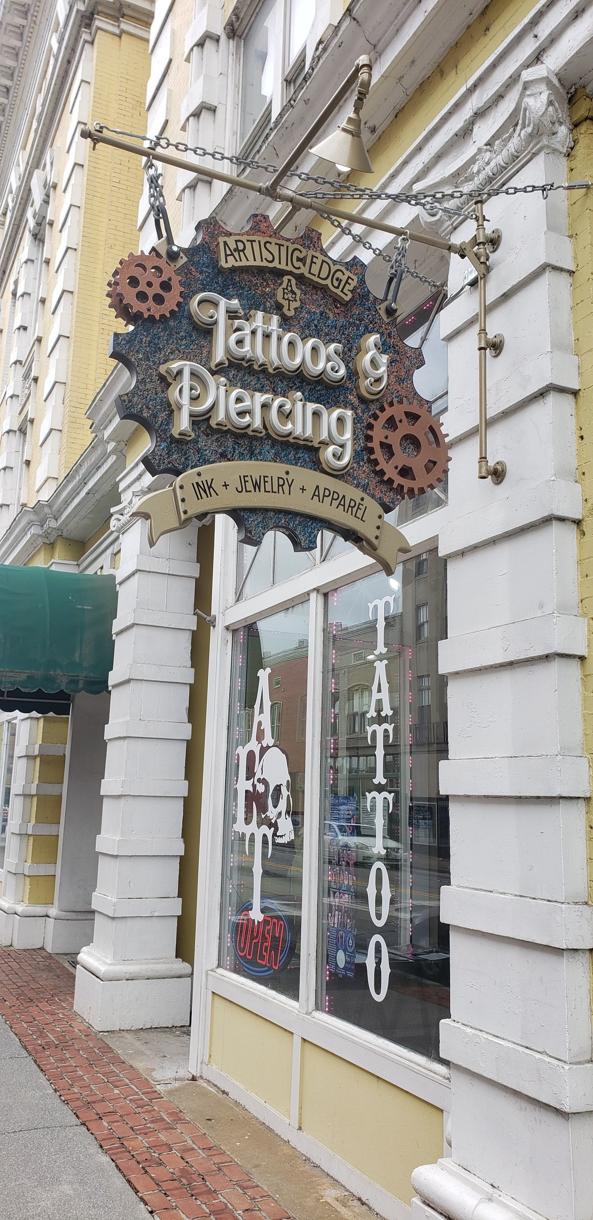Blade sign over storefront with tattoo window graphics, Artistic Edge Tattoos & Piercing, by High Stakes Creative