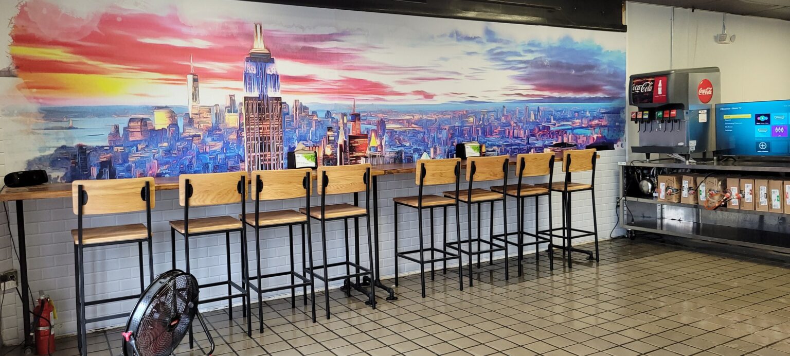 NYC skyline wall mural behind bar-height seating, Baby Tommy's Taste of New York, by High Stakes Creative