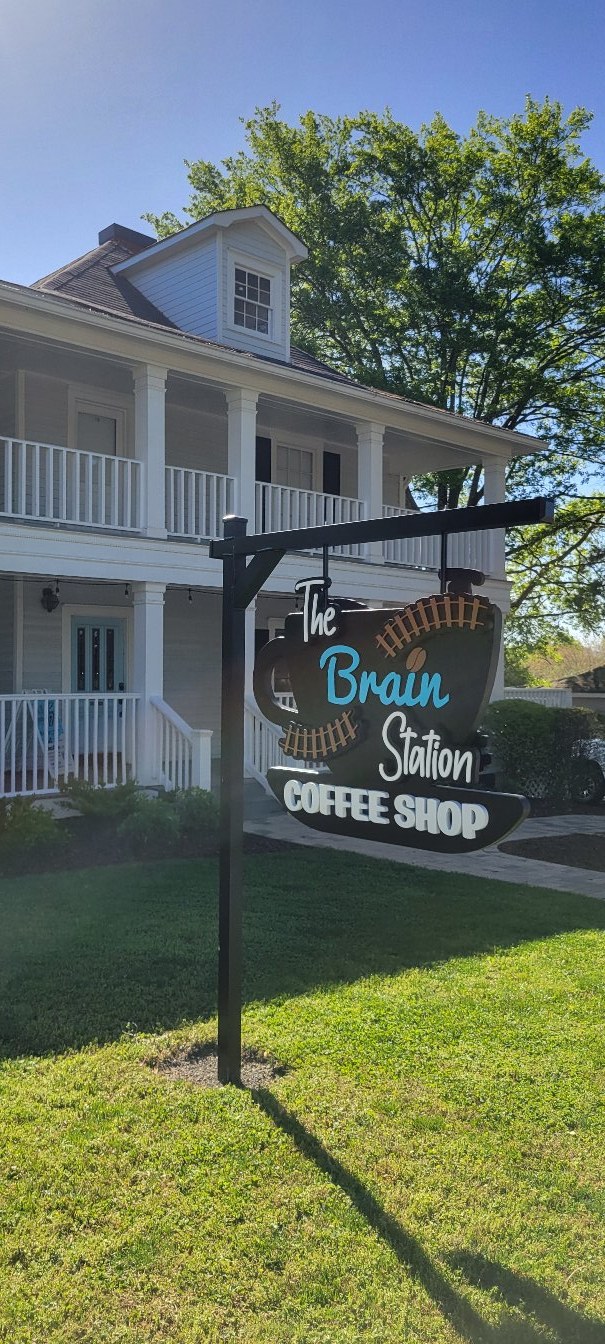 Sign in front of white house building, The Brain Station Coffee Shop, by High Stakes Creative