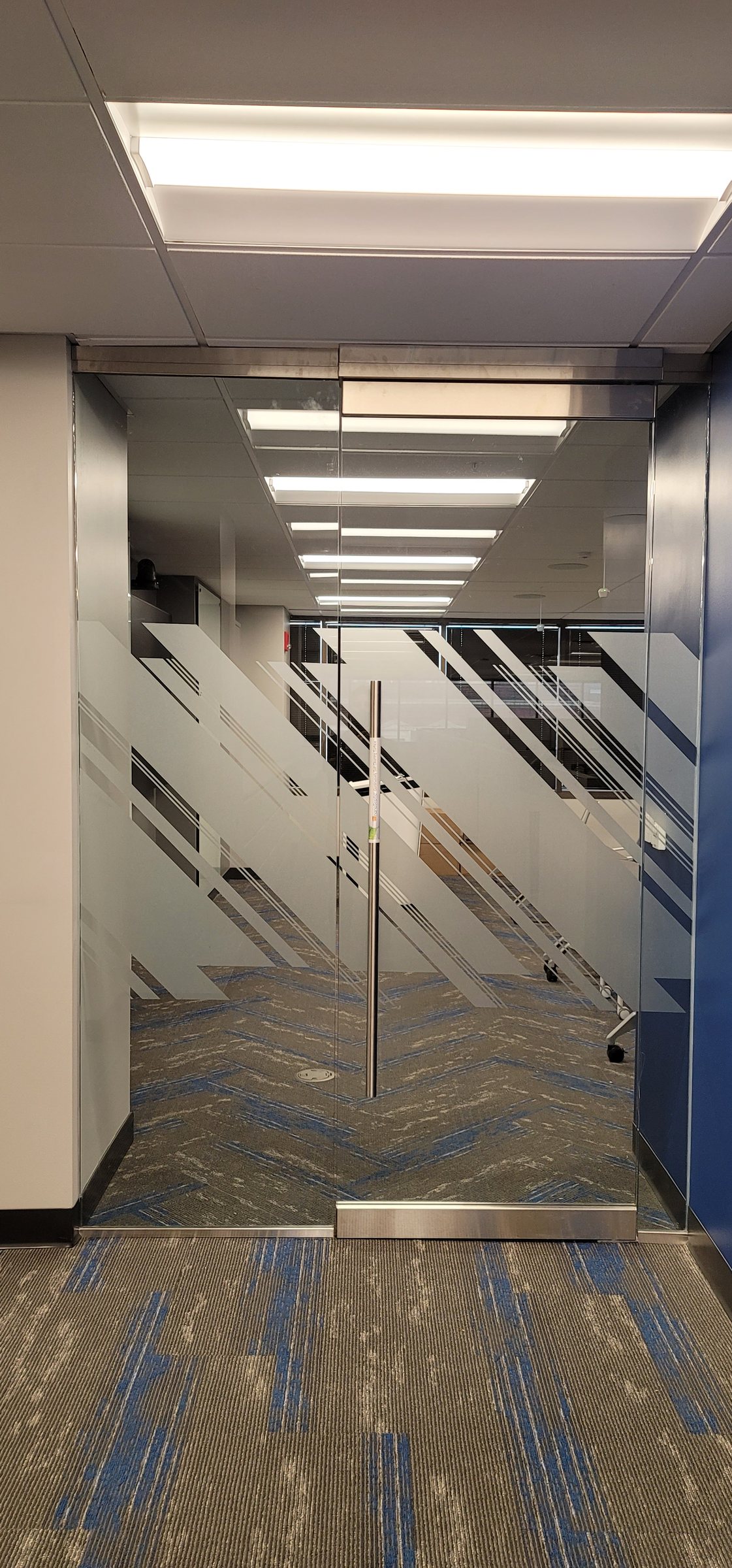 Frosted diagonal-stripe privacy film on glass entry doors, Burns & McDonnell, by High Stakes Creative