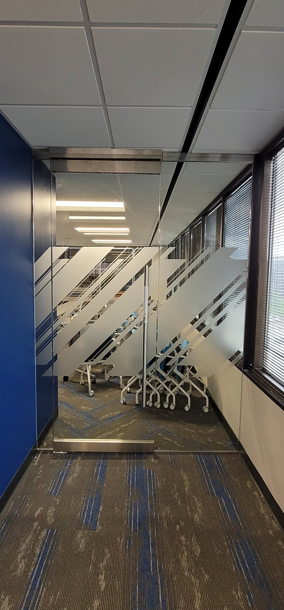 Glass partition film with diagonal stripes, corridor view, Burns & McDonnell, by High Stakes Creative