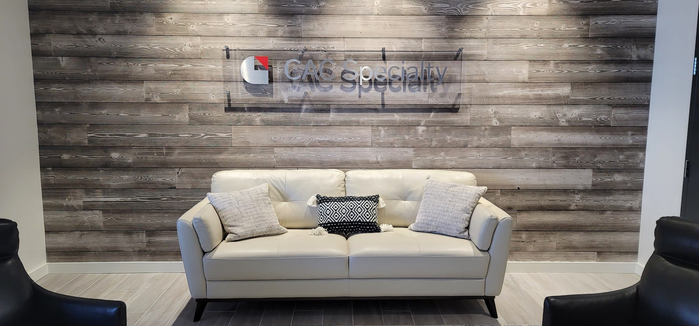 Lobby logo on wood plank wall above sofa, CAC Specialty, by High Stakes Creative