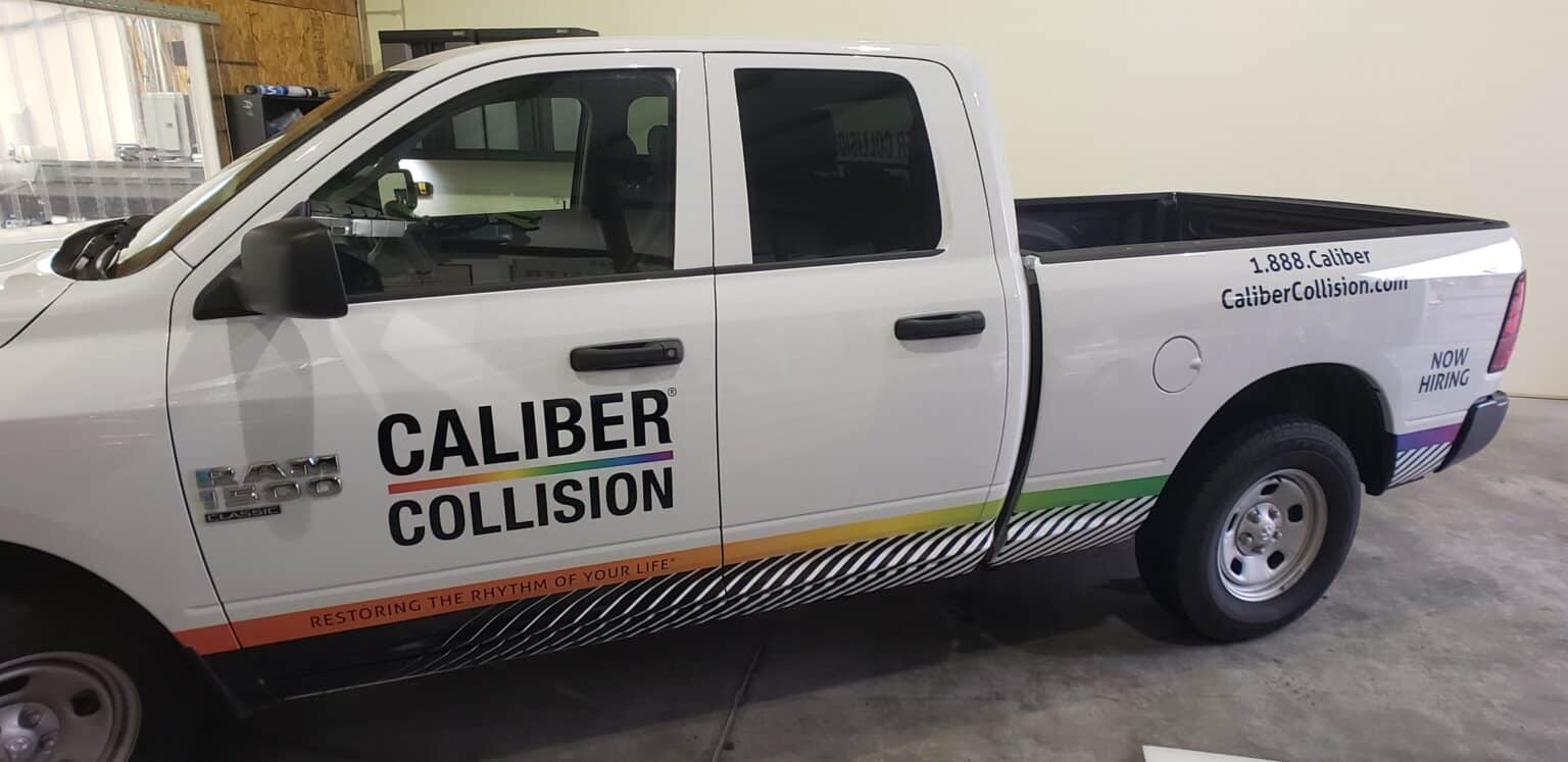 Door logo and rocker stripe graphics on a white Ram pickup, Caliber Collision, by High Stakes Creative
