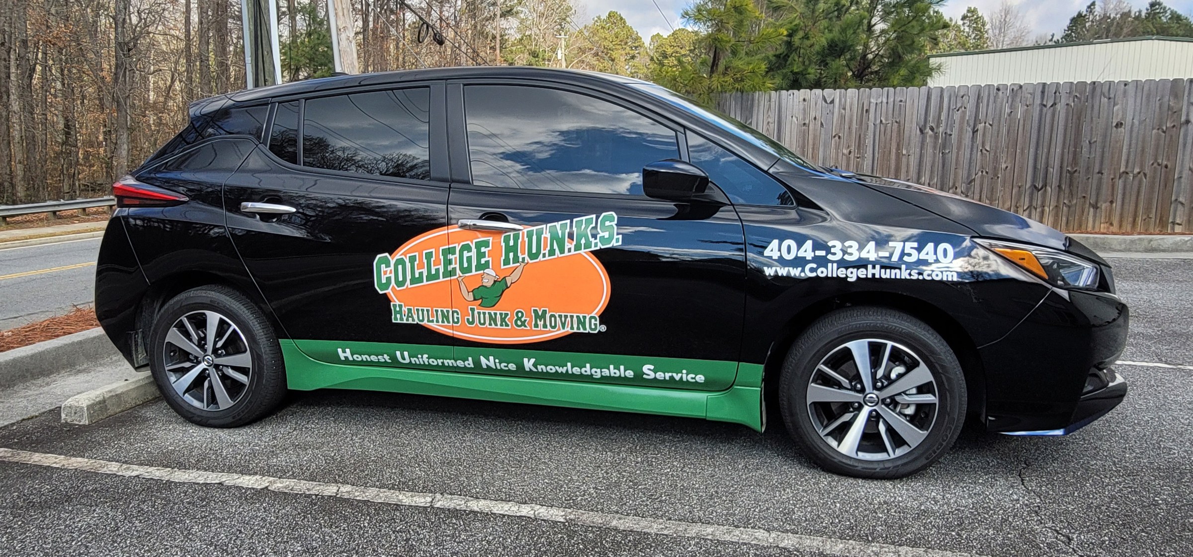 Logo, phone, web and green rocker graphics on a black Nissan Leaf, College Hunks Hauling Junk & Moving, by High Stakes Creative