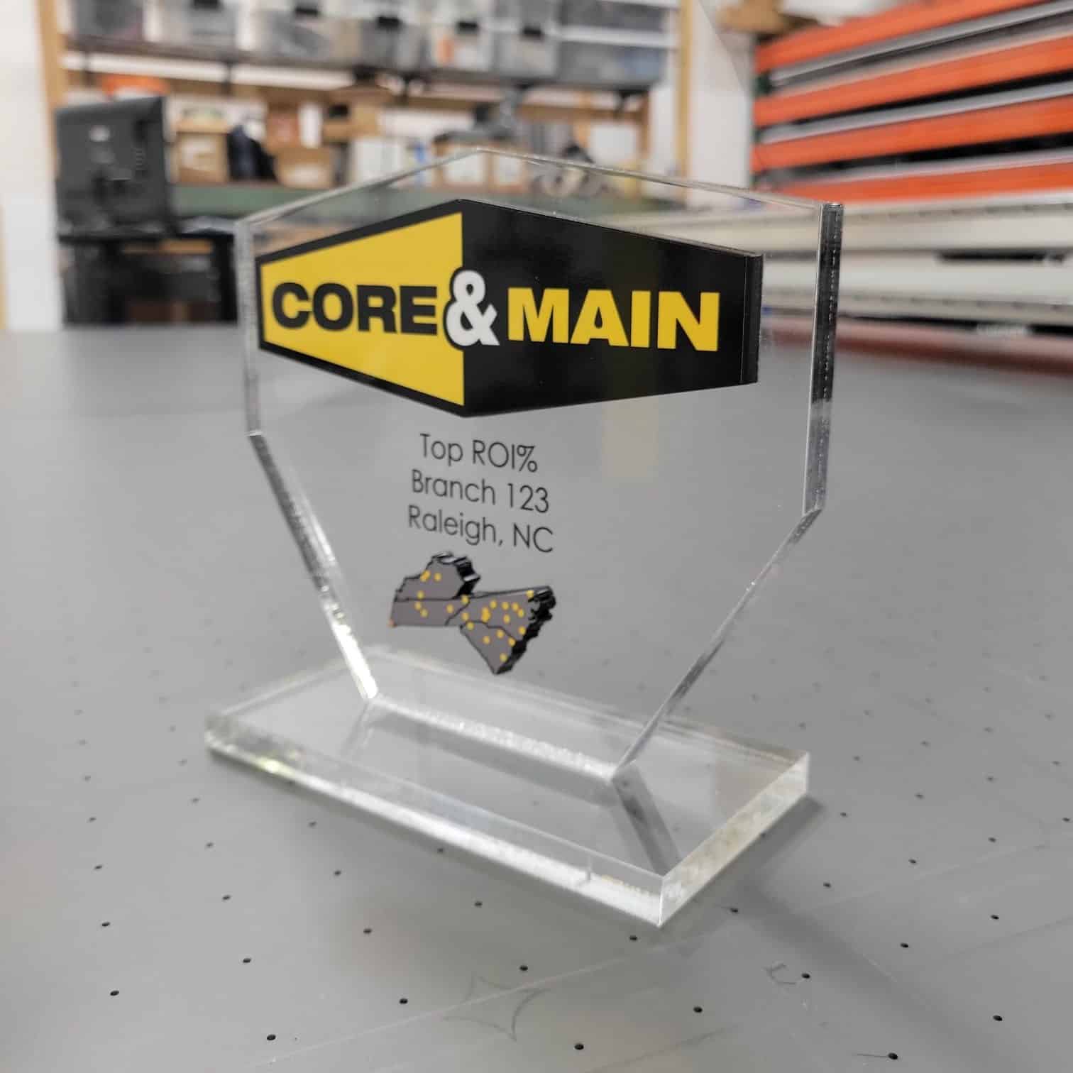Clear acrylic branch awards printed with Core & Main logo and region map, plus engraved le, Core & Main, by High Stakes Creative