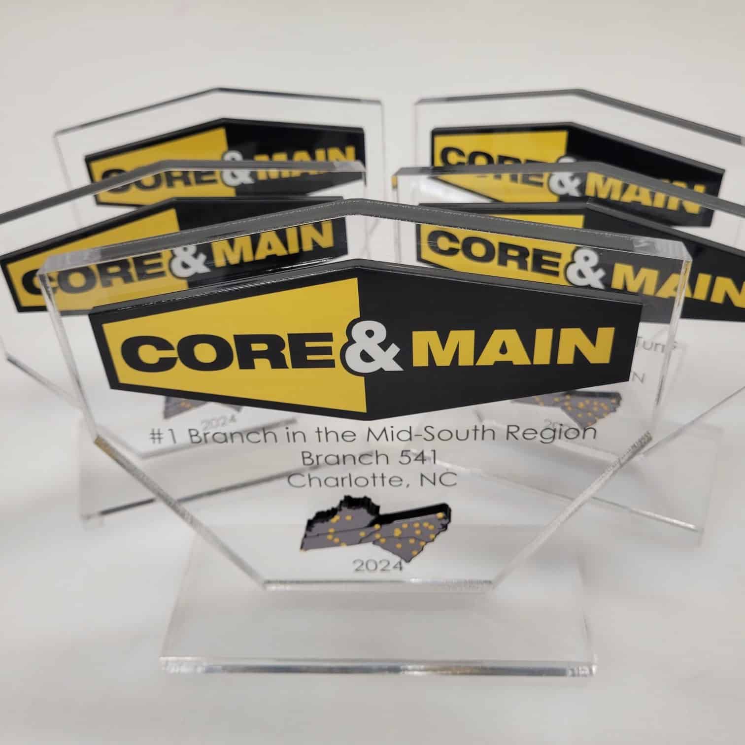 Clear acrylic branch awards printed with Core & Main logo and region map, plus engraved le, Core & Main, by High Stakes Creative