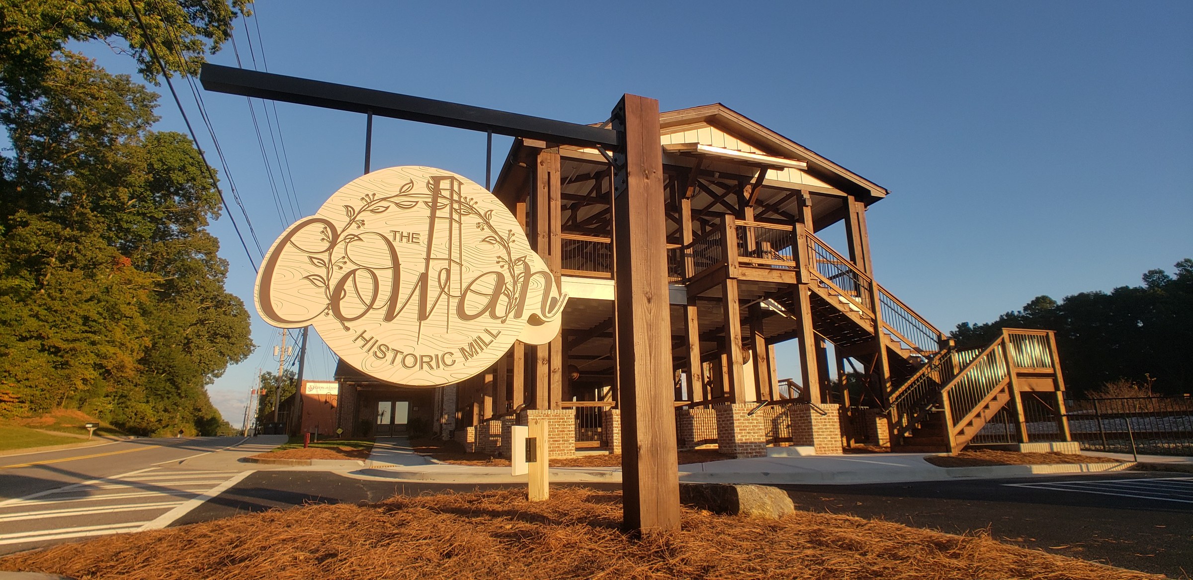 Carved hanging sign on a stained wood post, The Cowan Historic Mill, Acworth, GA, by High Stakes Creative