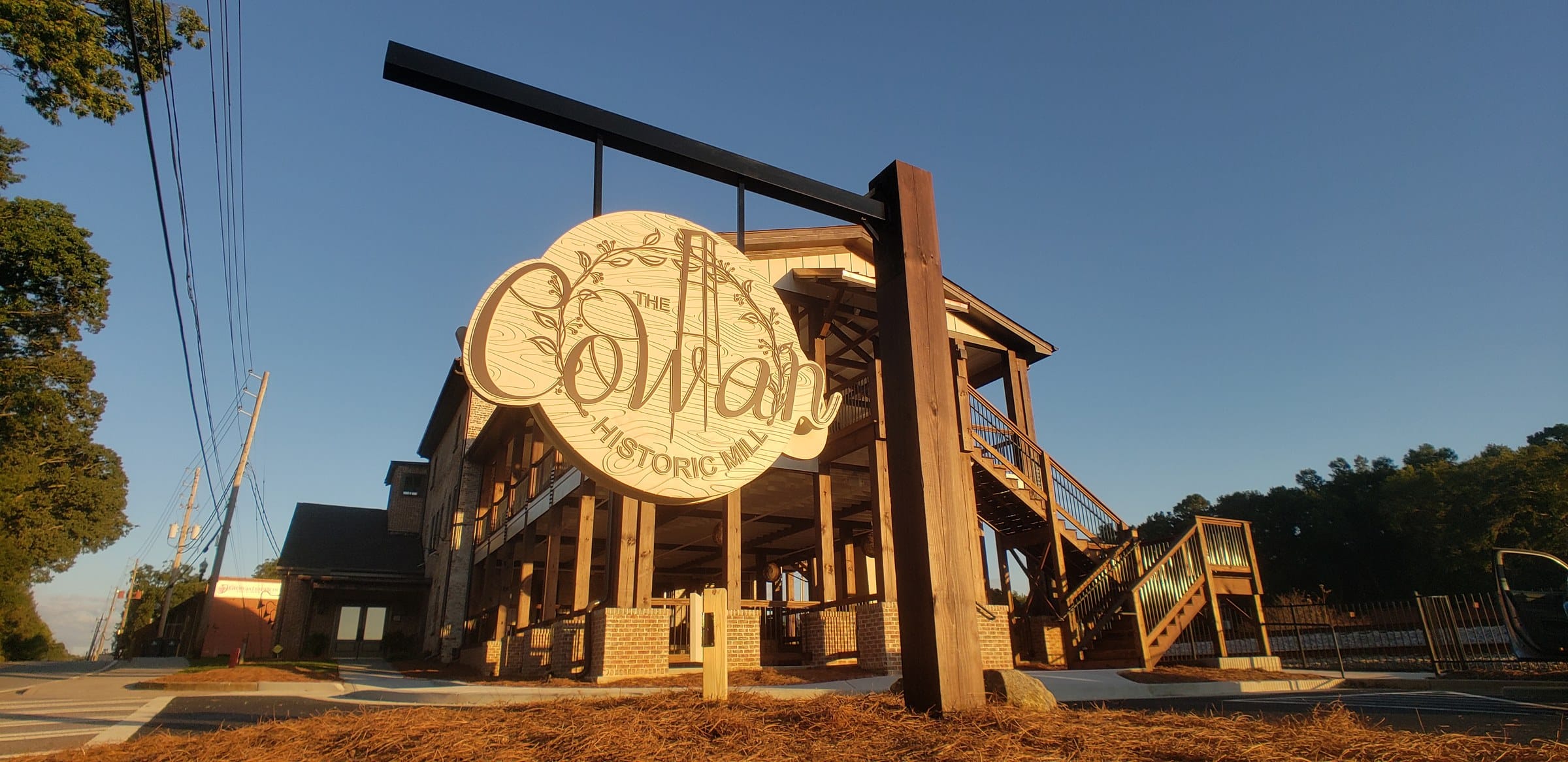 Carved hanging sign, low angle, The Cowan Historic Mill, Acworth, GA, by High Stakes Creative