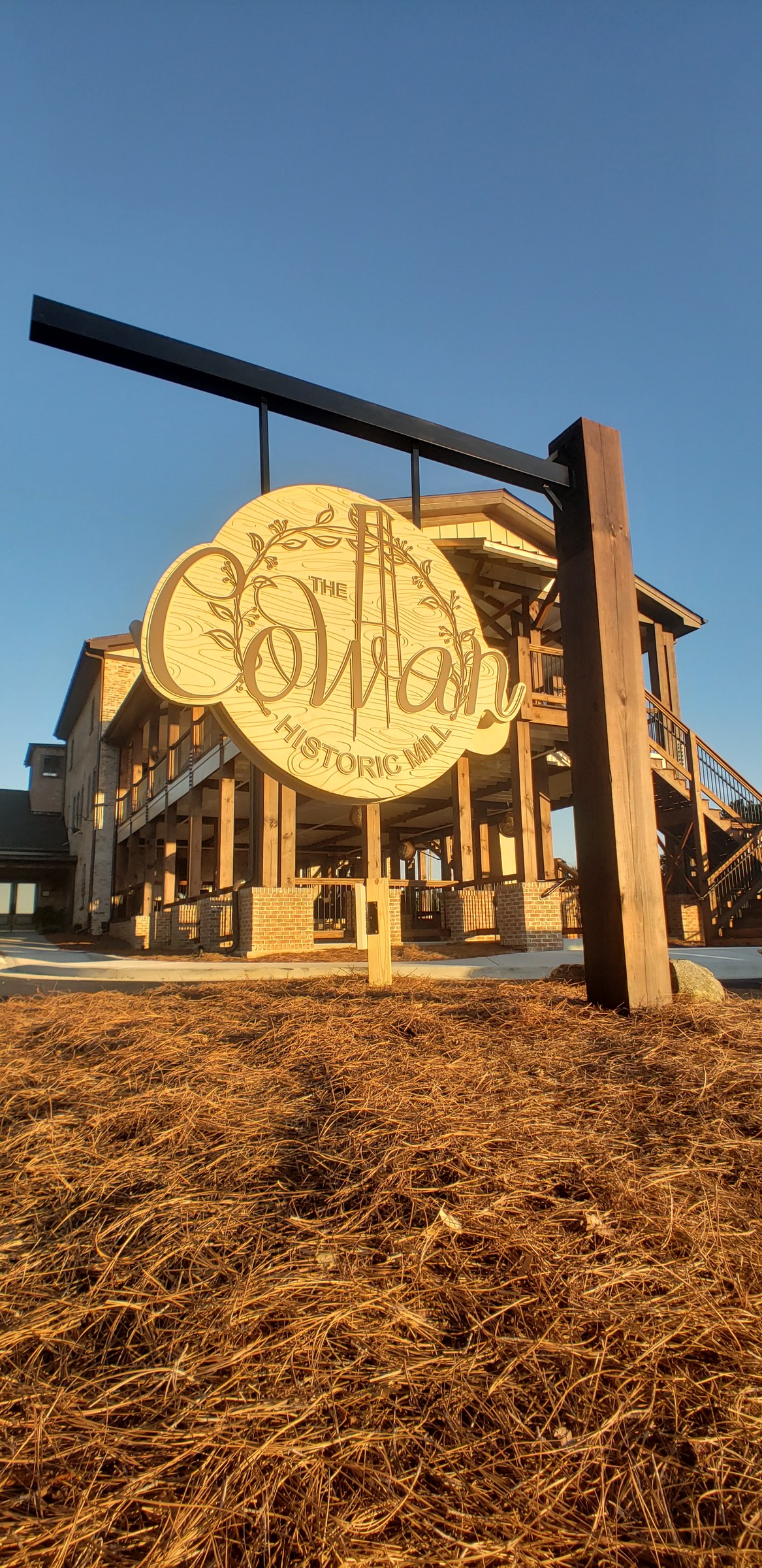Carved hanging sign and mill building, The Cowan Historic Mill, Acworth, GA, by High Stakes Creative
