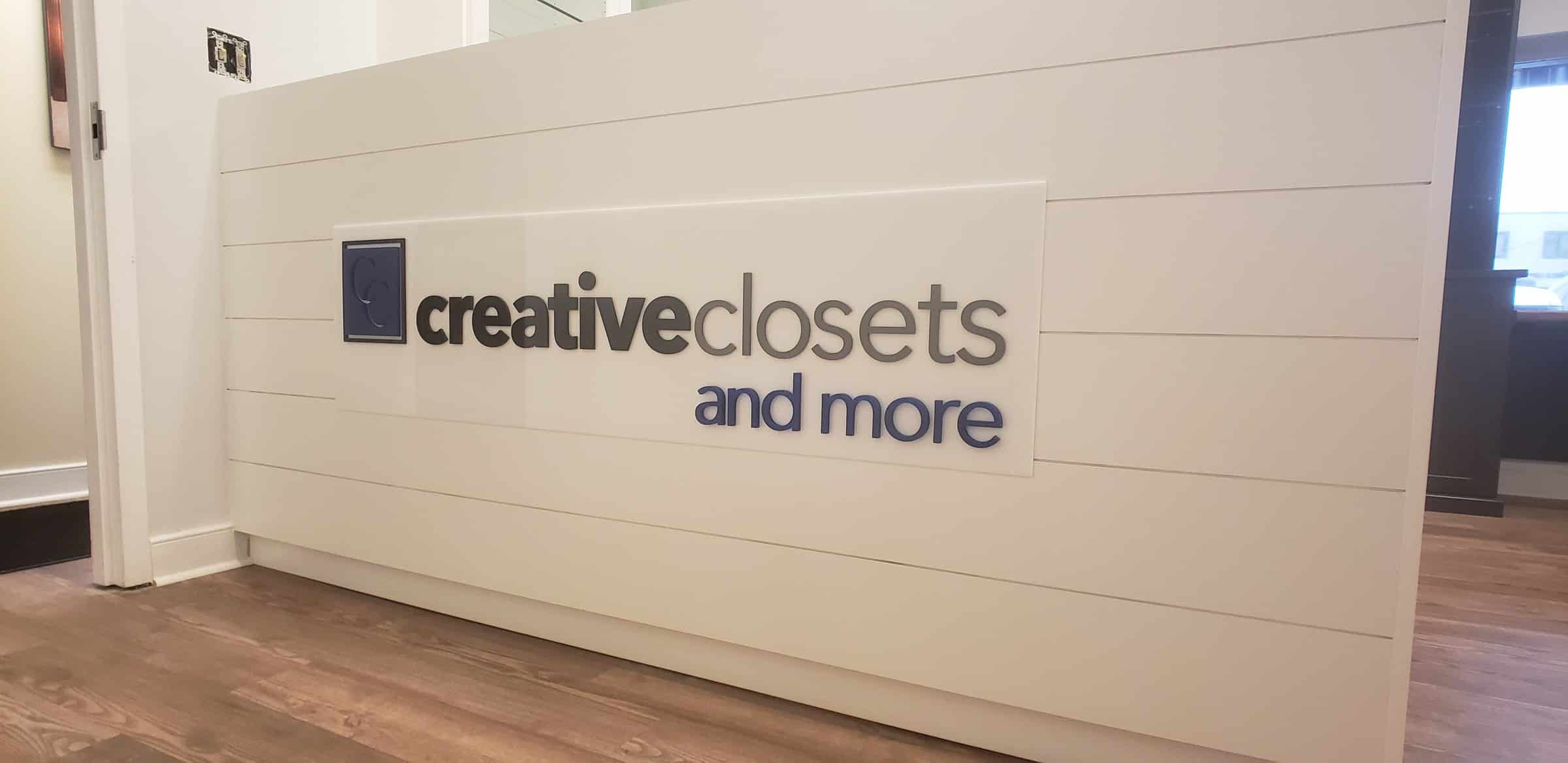 Dimensional logo panel on white shiplap reception desk, Creative Closets and More, by High Stakes Creative