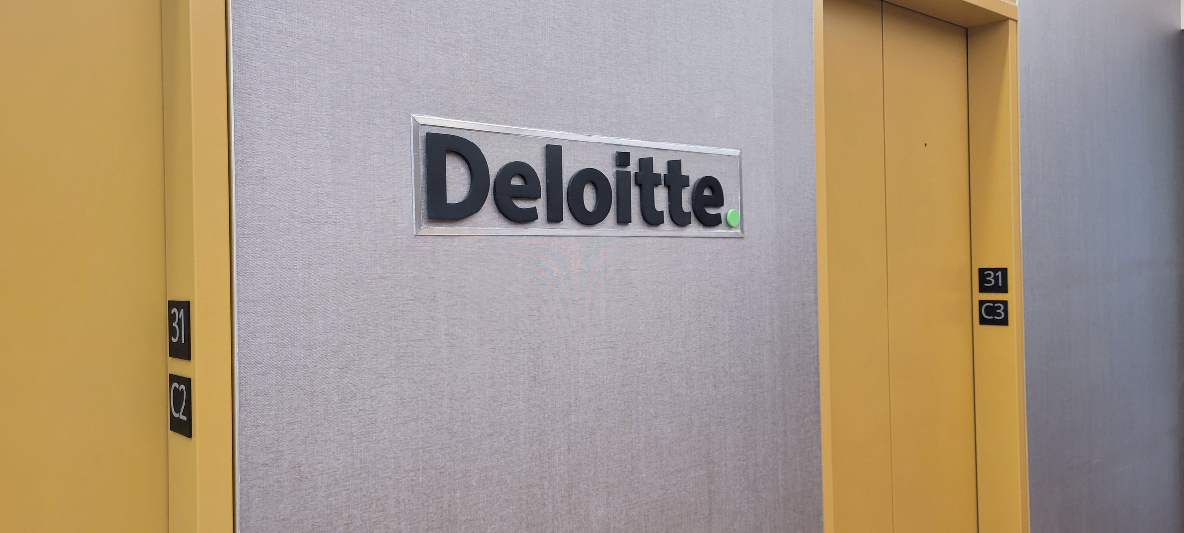 Dimensional logo on fabric wall at elevator bay, Deloitte, by High Stakes Creative