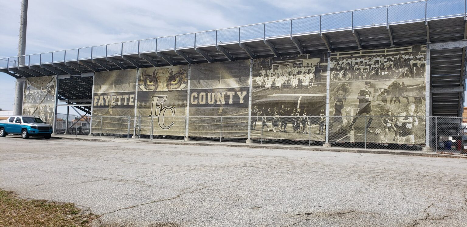 Large-format historic photo banners on stadium grandstand, Fayette County, by High Stakes Creative