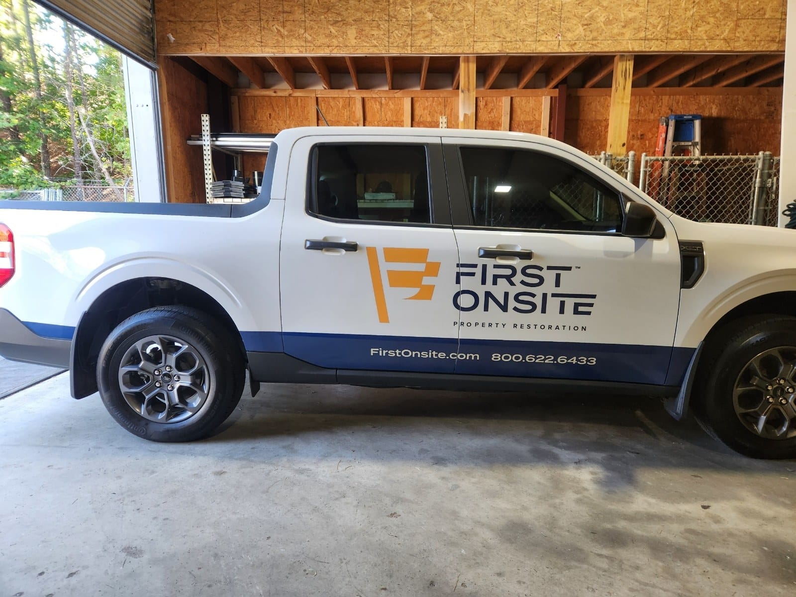 Logo, web and phone graphics with blue lower band on a white Ford Maverick, First Onsite Property Restoration, by High Stakes Creative