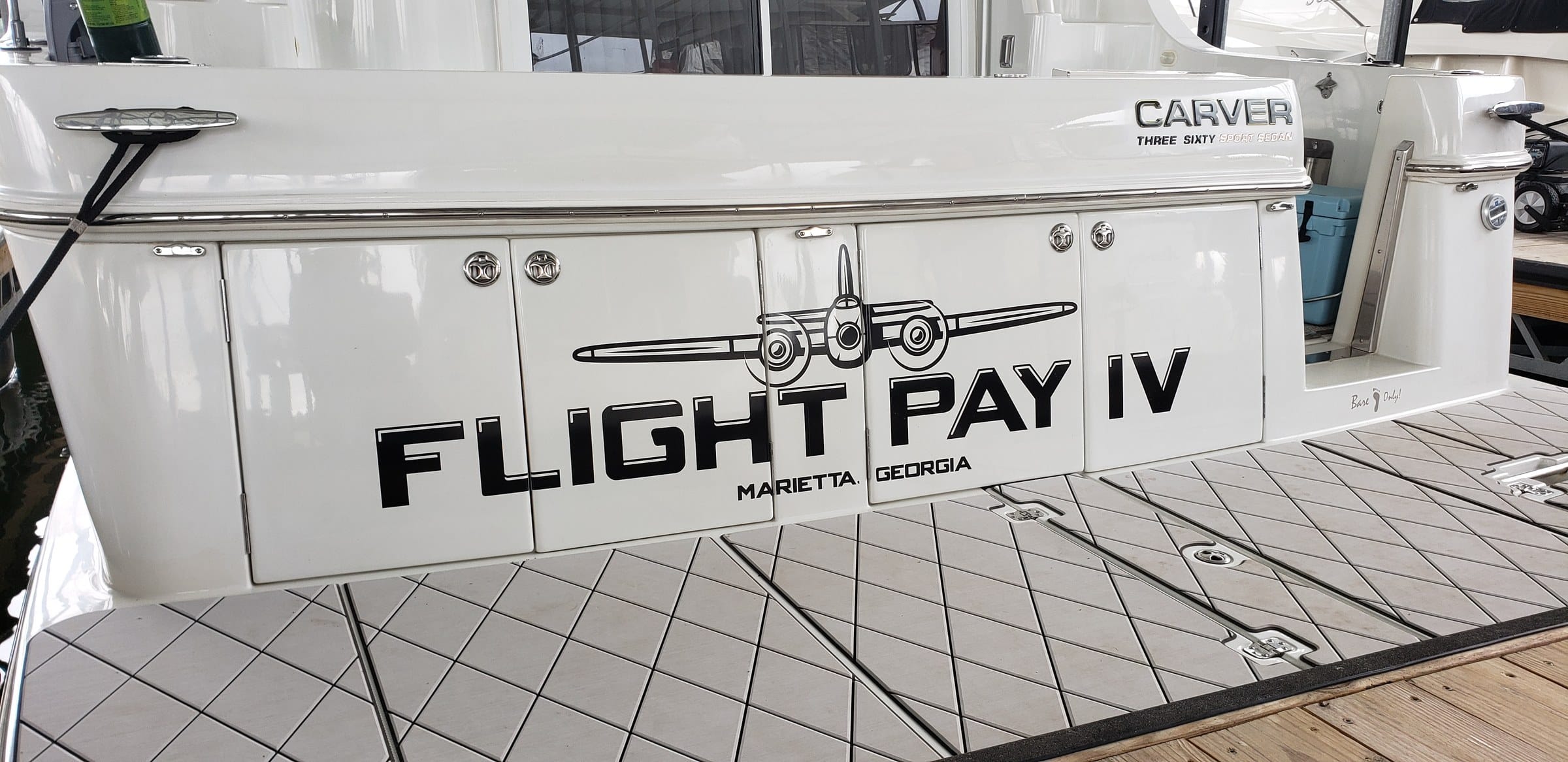 Boat transom name lettering with twin-prop airplane graphic on a Carver yacht, Flight Pay IV, by High Stakes Creative