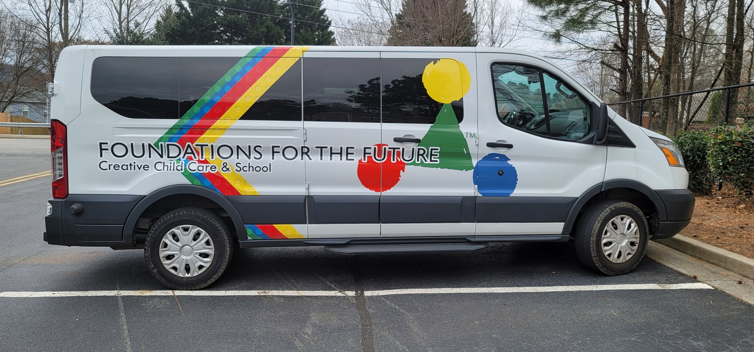Colorful stripe and shape graphics with name lettering on a white Ford Transit van, Foundations for the Future Creative Child Care & School, by High Stakes Creative