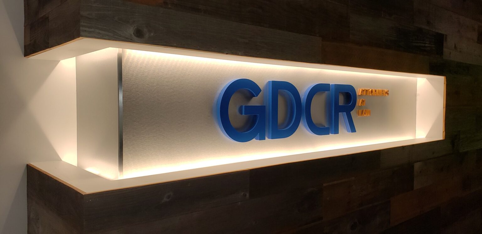 Backlit lobby sign box with GDCR letters on reclaimed wood wall, GDCR Attorneys at Law, Marietta, GA, by High Stakes Creative