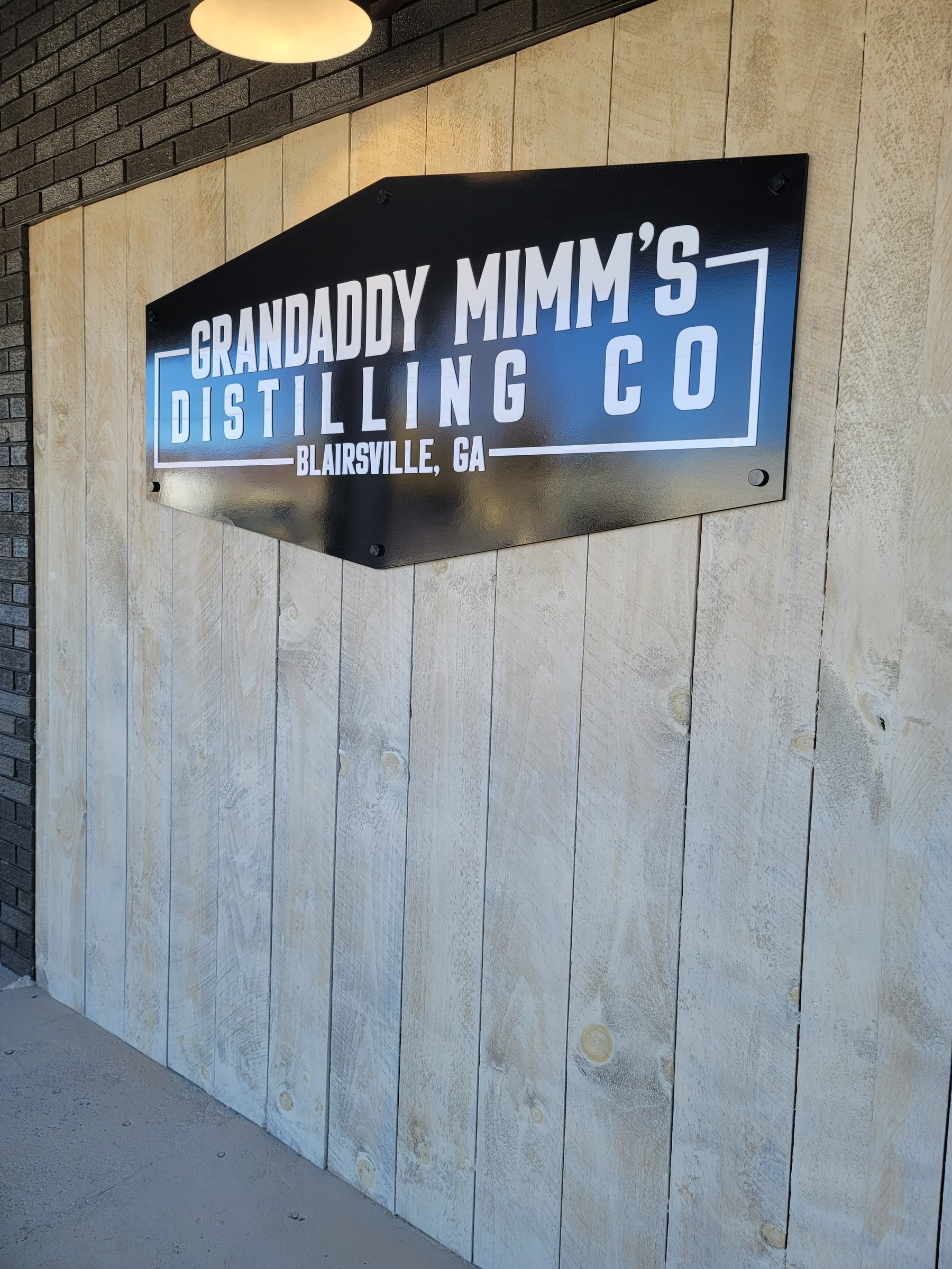 Panel sign on plank wall, wider view, Grandaddy Mimm's Distilling Co., Blairsville, GA, by High Stakes Creative