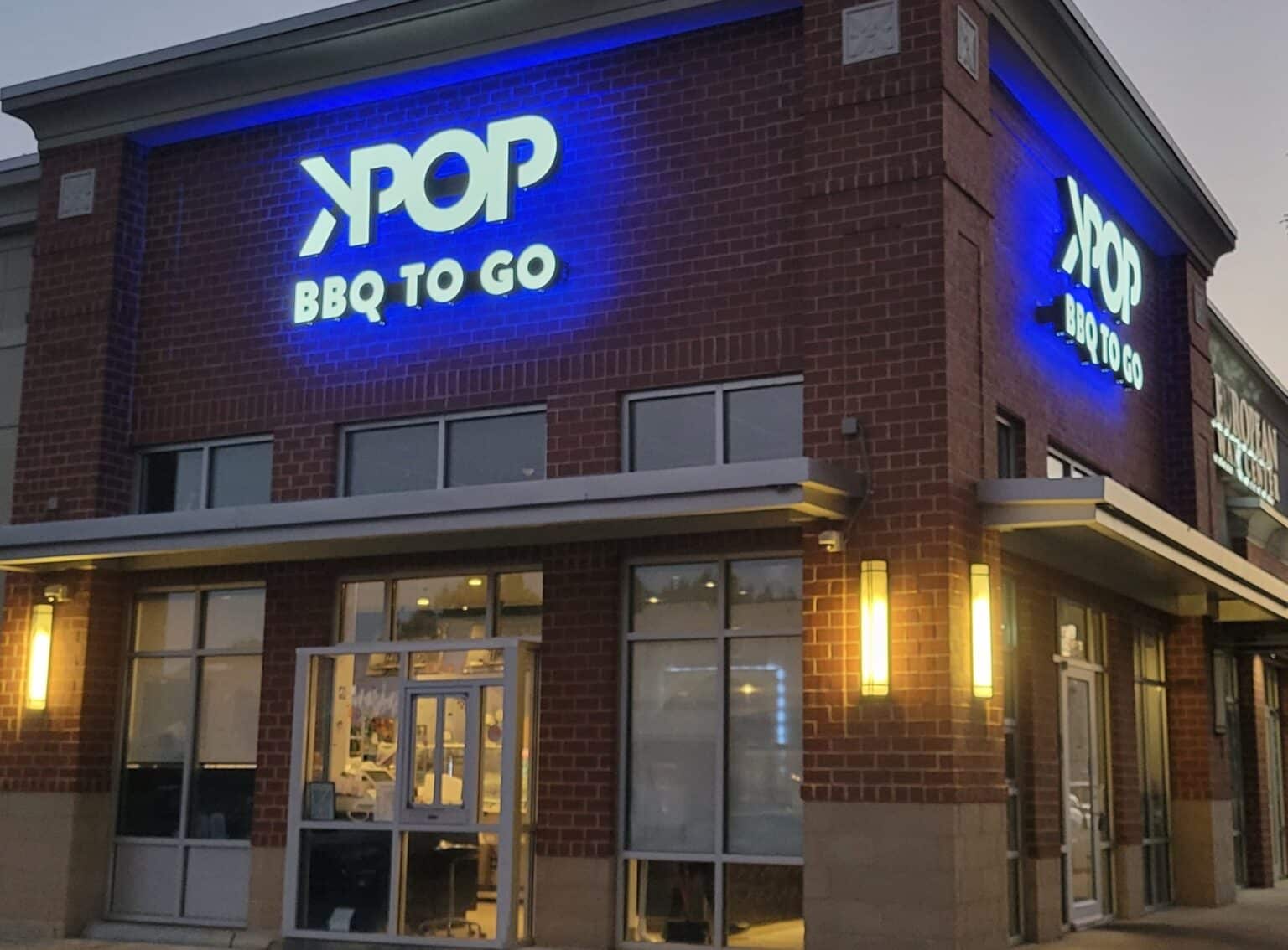 Blue-lit KPOP BBQ To Go channel letters on brick at dusk, KPOP BBQ To Go, by High Stakes Creative