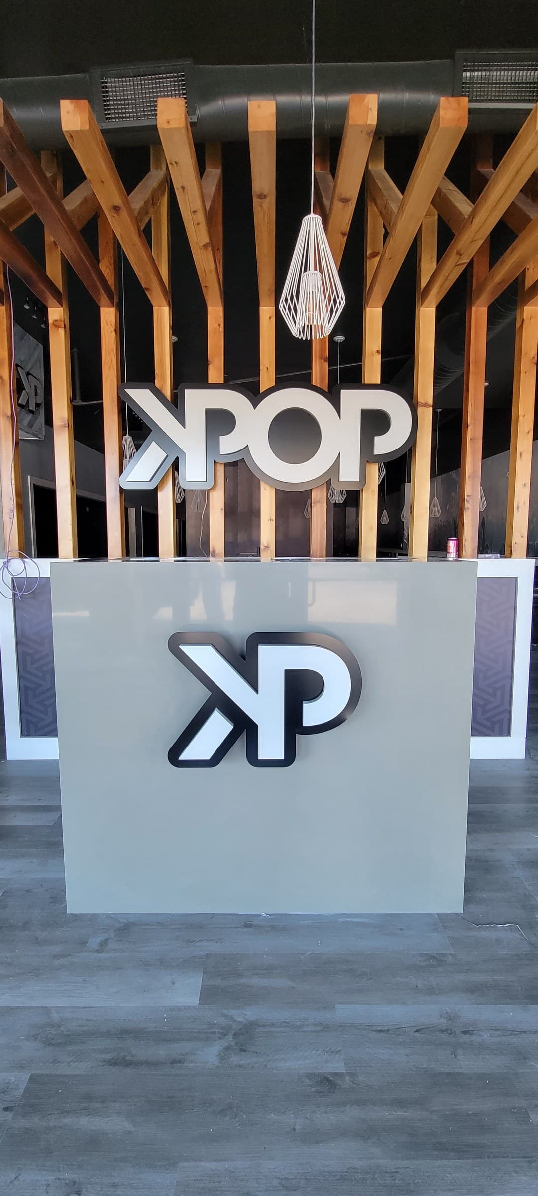 Lit KPOP logo on slatted wood above counter, KPOP BBQ To Go, by High Stakes Creative