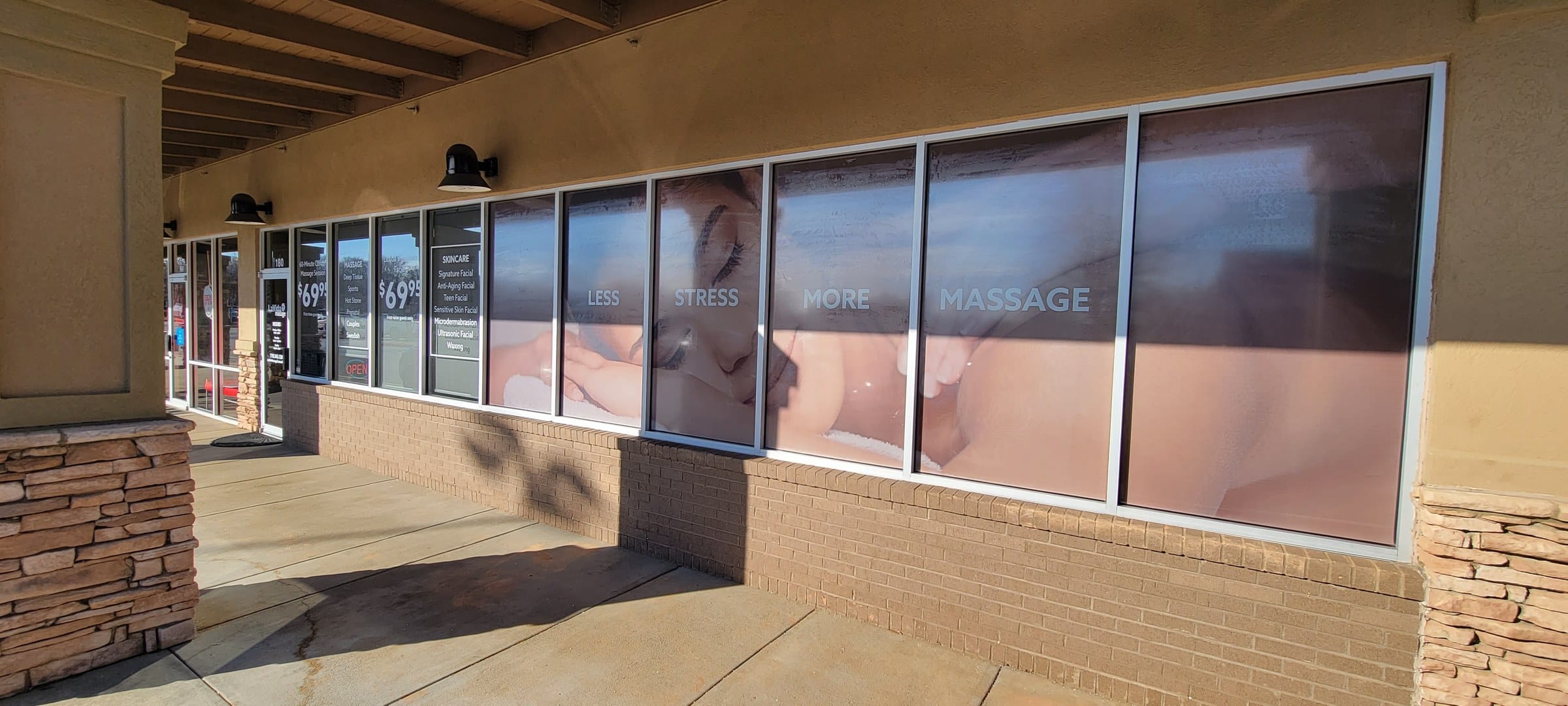 Storefront window graphics: door hours/logo decal, price window and full-height lifestyle , LaVida Massage, Canton, GA, by High Stakes Creative