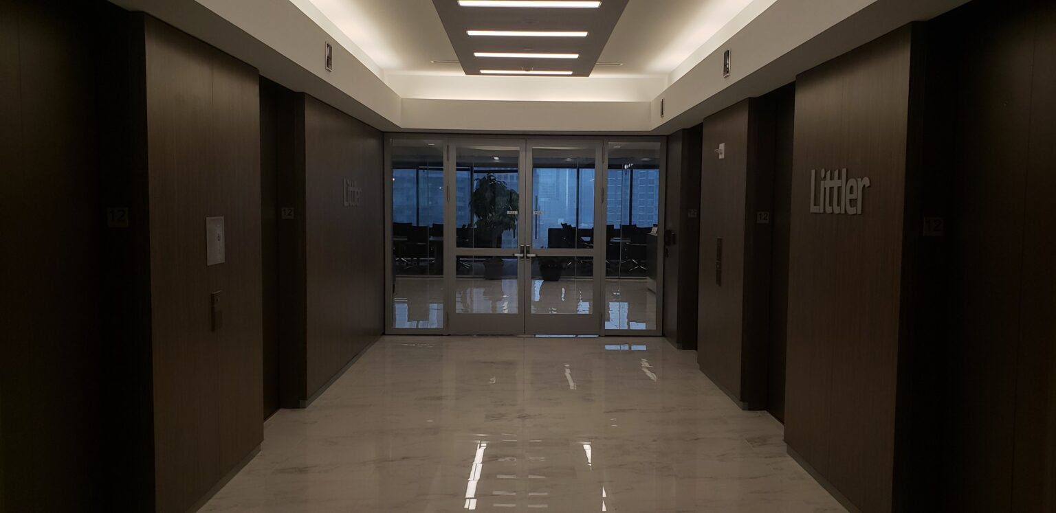 Brushed-metal dimensional "Littler" lettering on dark wood elevator-lobby walls, 12th floo, Littler, Atlanta, GA, by High Stakes Creative