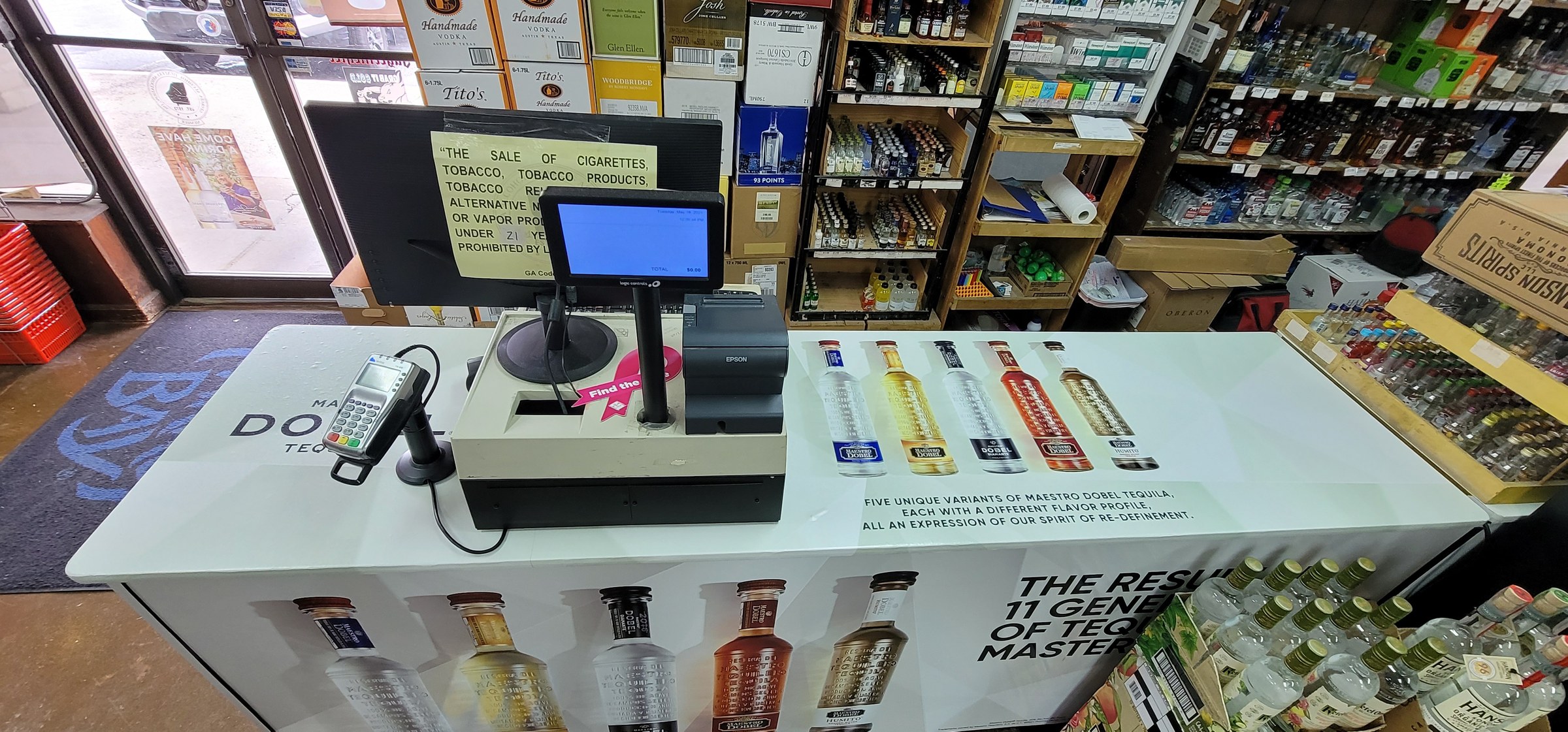 Printed wrap on liquor-store checkout counters showing Maestro Dobel bottles and tagline, Maestro Dobel Tequila, by High Stakes Creative