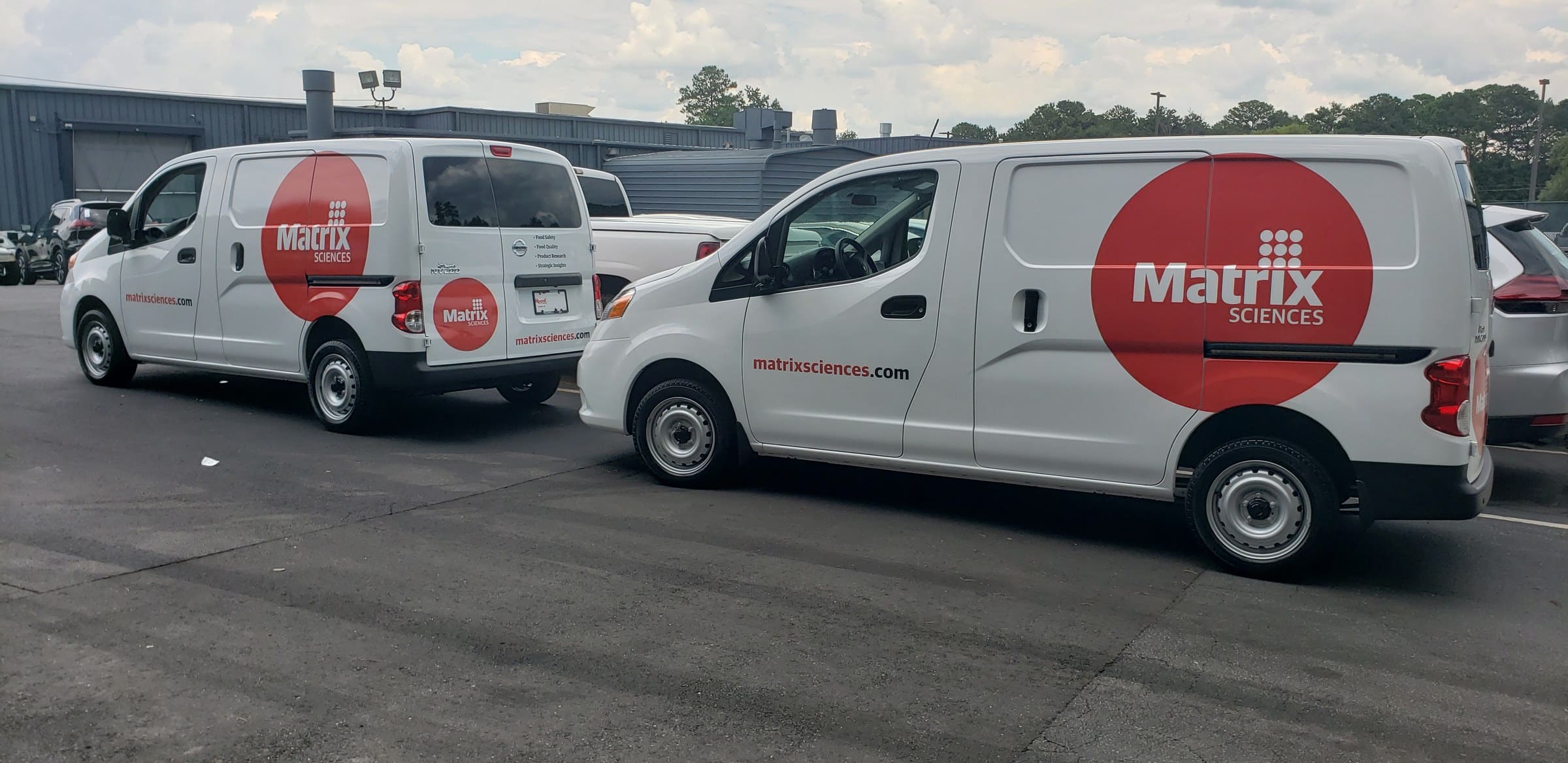 Red circle logo graphics on two white Nissan NV200 vans, Matrix Sciences, by High Stakes Creative