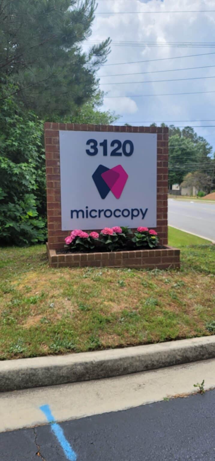 Brick monument with 3120 Microcopy panel and flower bed, Microcopy, Kennesaw, GA, by High Stakes Creative