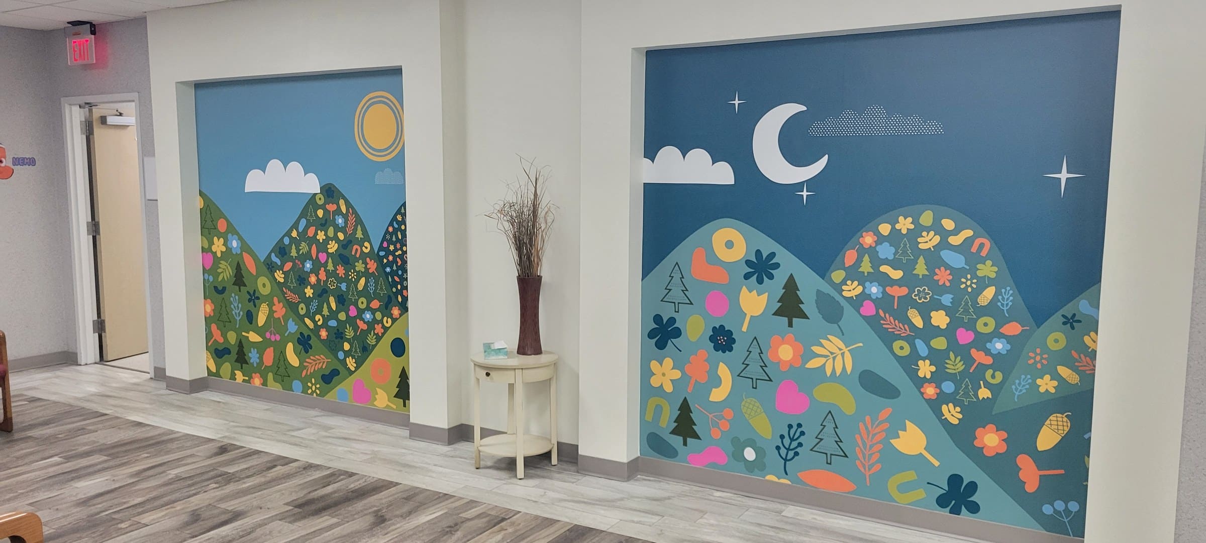 Illustrated mountain/flower/sun wall murals in office rooms and a framed lobby wall (day a, by High Stakes Creative