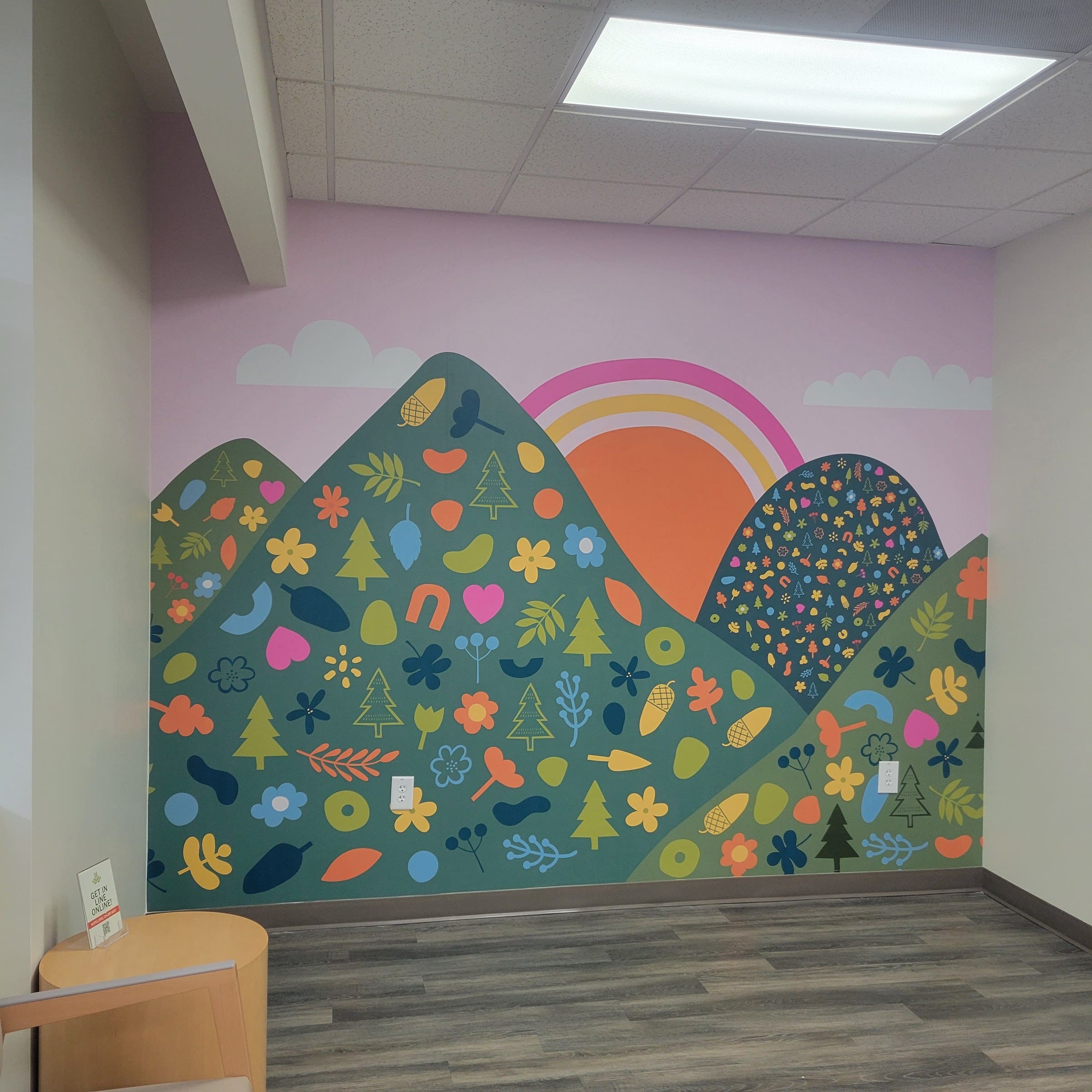 Illustrated mountain/flower/sun wall murals in office rooms and a framed lobby wall (day a, by High Stakes Creative
