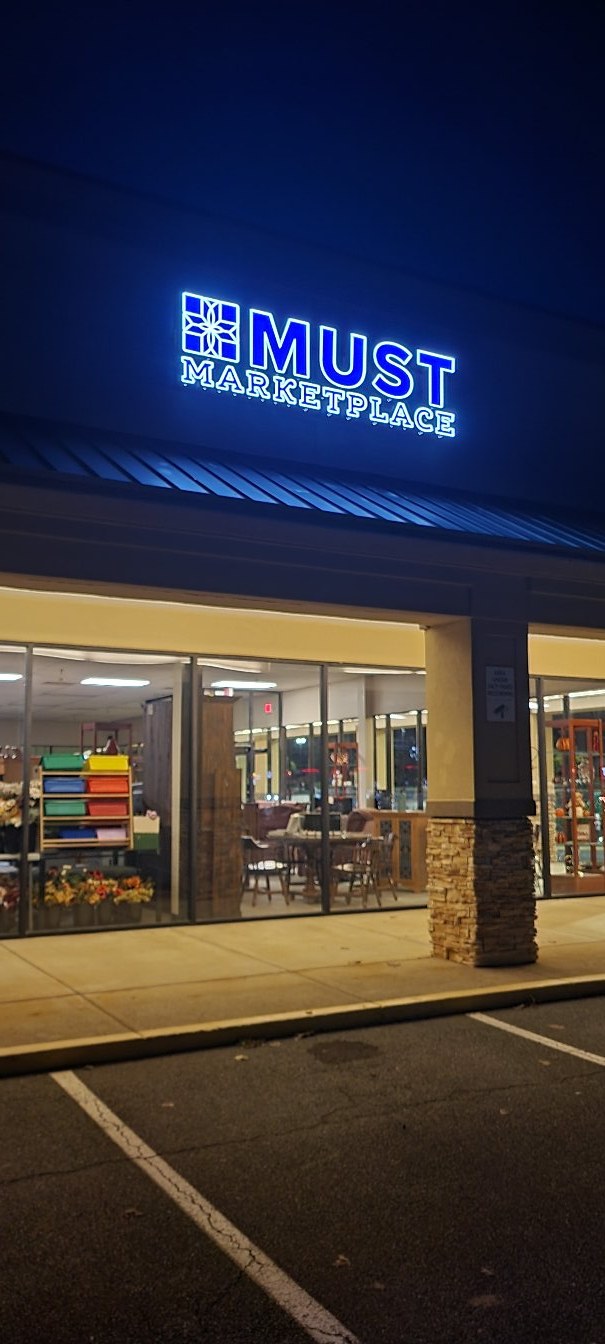 Blue-lit MUST Marketplace letters at night, MUST Marketplace, by High Stakes Creative