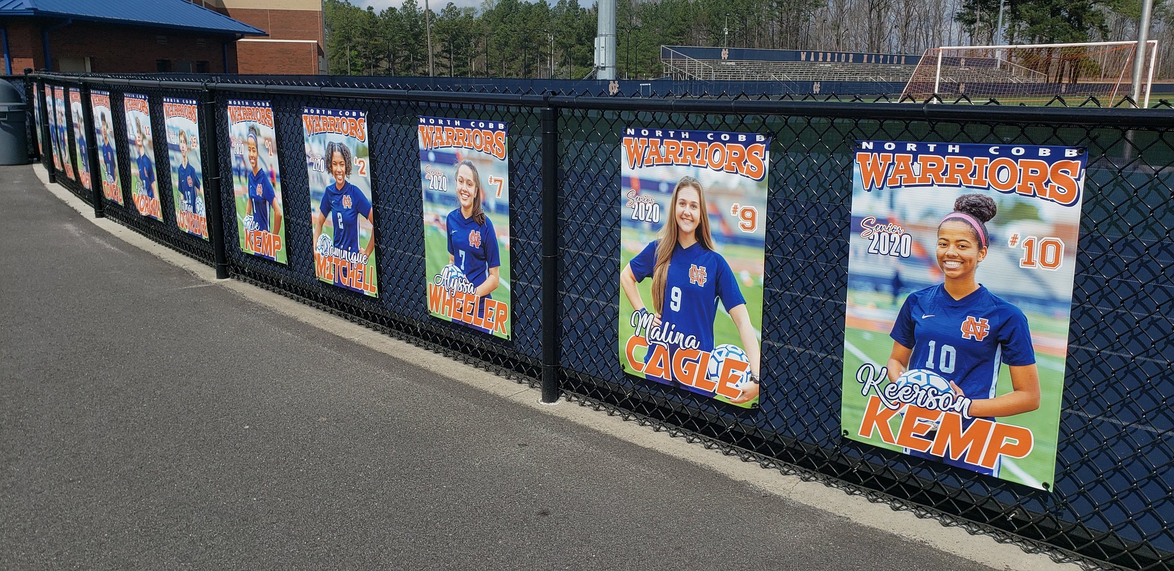 Senior athlete photo banners on fence line, North Cobb Warriors, by High Stakes Creative