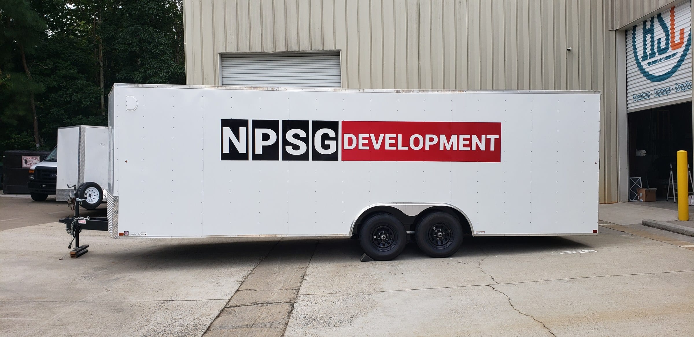 NPSG Development logo on a white enclosed tandem-axle trailer, NPSG Development, by High Stakes Creative