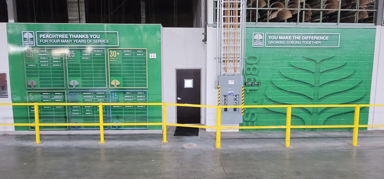 Warehouse wall graphics: green leaf mural with "You Make The Difference / Growing Strong T, Peachtree Packaging & Display, by High Stakes Creative