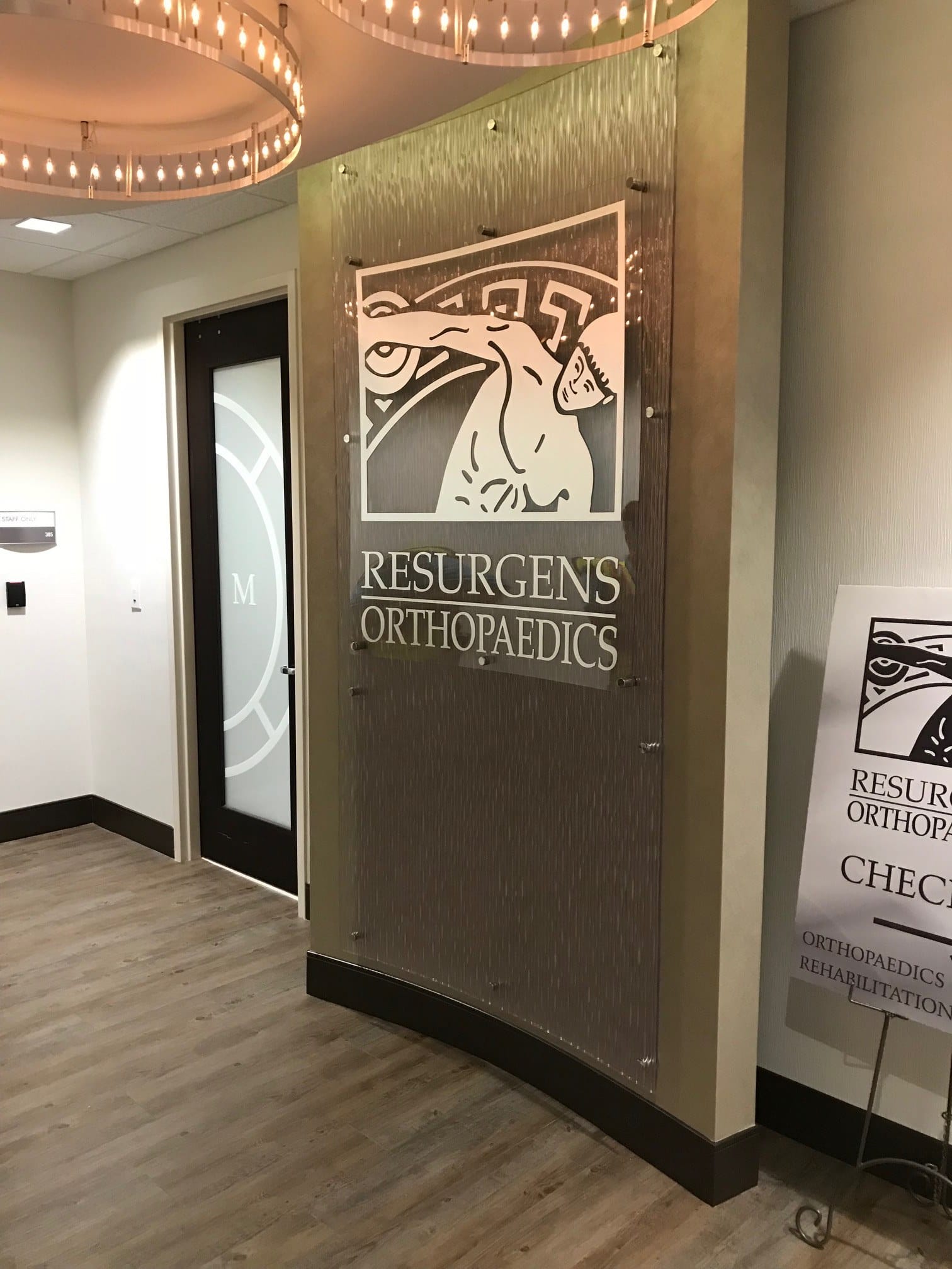 Curved textured lobby feature panel with standoff-mounted logo panel, Resurgens Orthopaedics, by High Stakes Creative