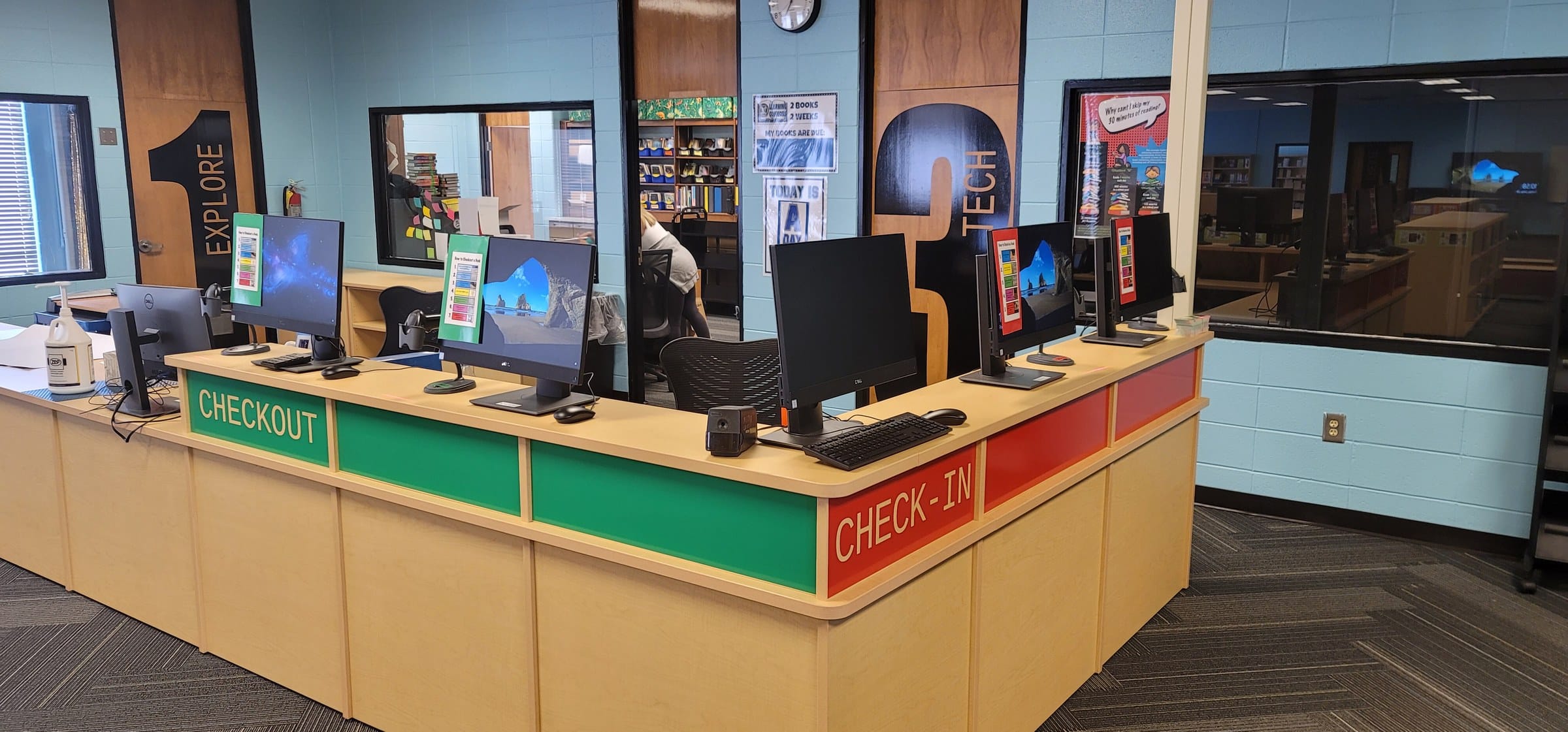 Library checkout / check-in counter wrap with numbered door graphics behind, by High Stakes Creative