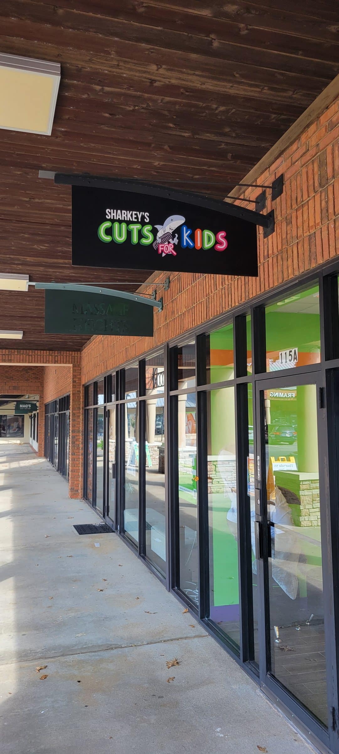 Hanging blade sign under walkway canopy, Sharkey's Cuts for Kids, Johns Creek, GA, by High Stakes Creative