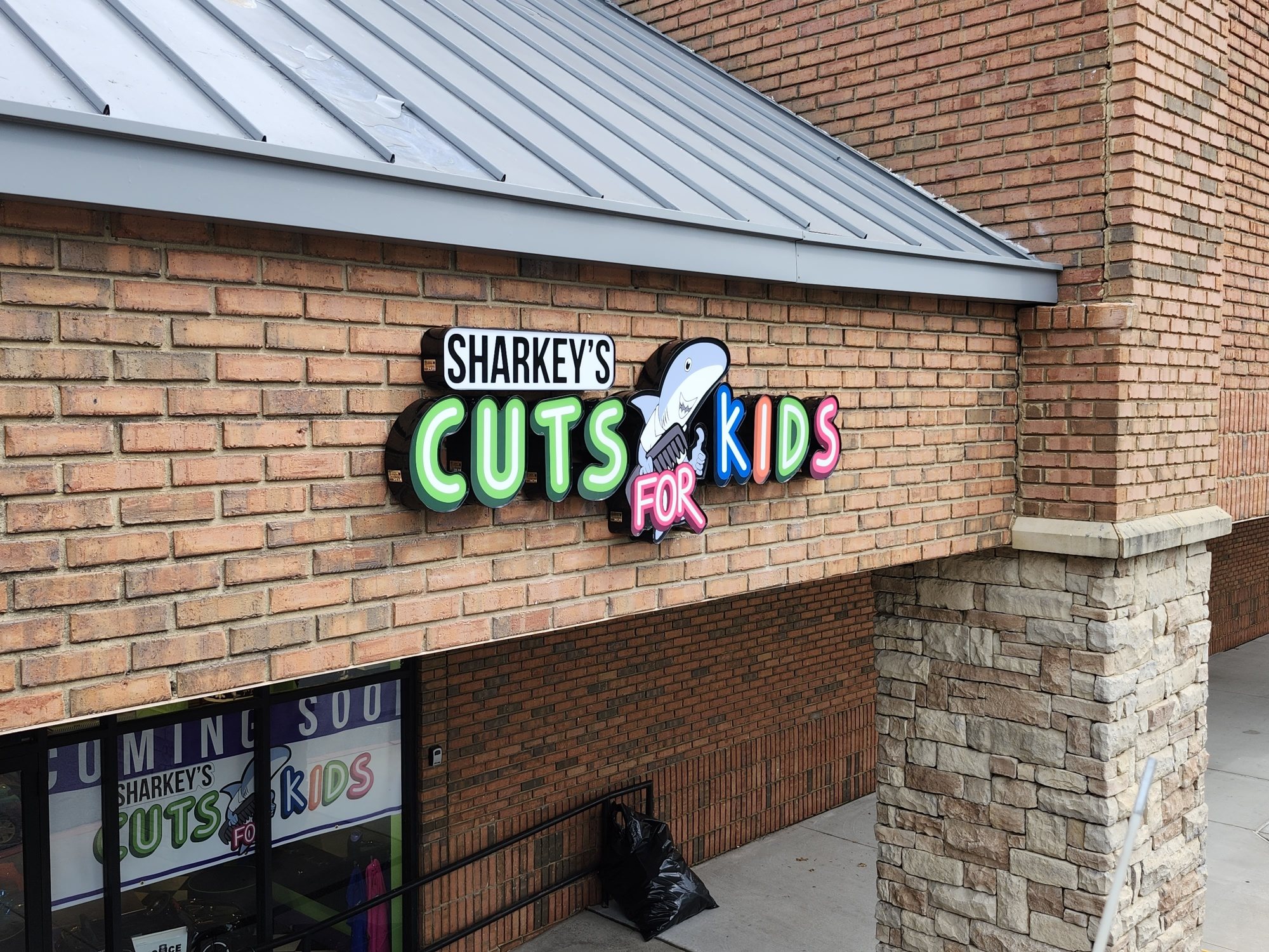 Illuminated channel letter sign with shark logo, Sharkey's Cuts for Kids, Johns Creek, GA, by High Stakes Creative