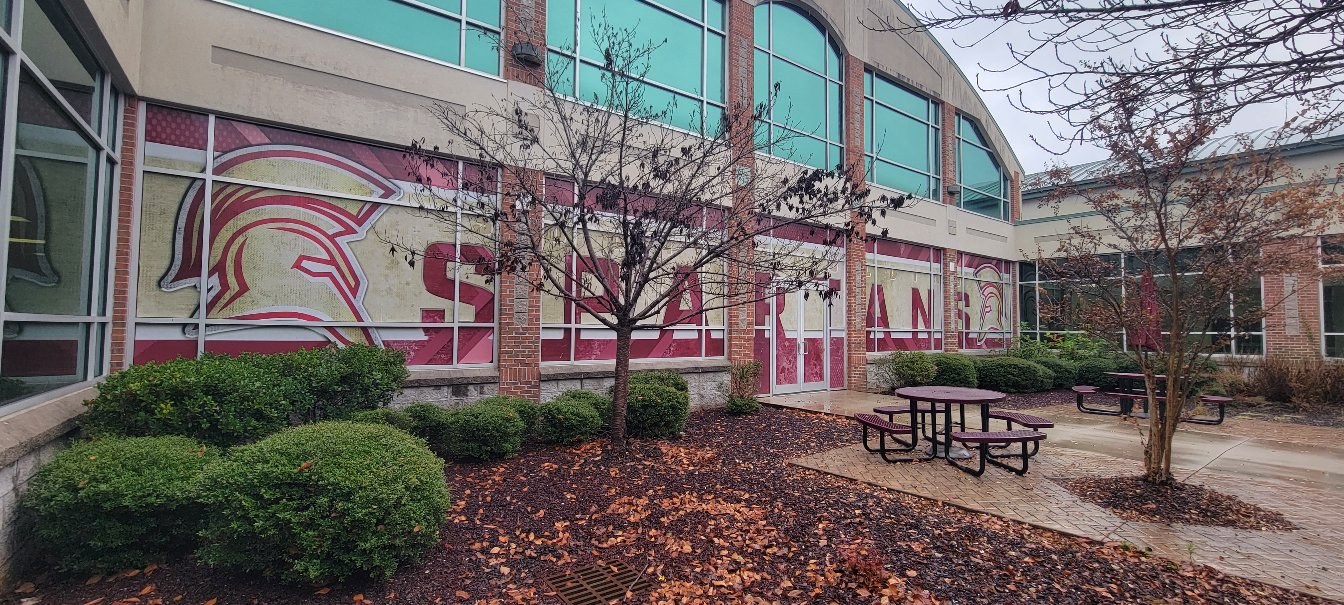 Large SPARTANS lettering and Spartan helmet graphics across school building windows, Spartans, by High Stakes Creative